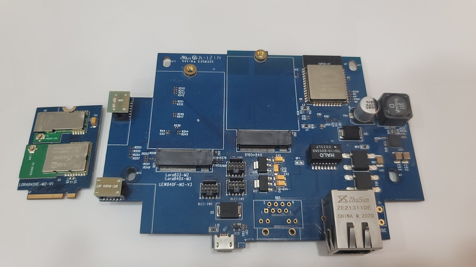 The LEW840X opened, with the M.2 radio card lifted out of its slot and lying beside the board