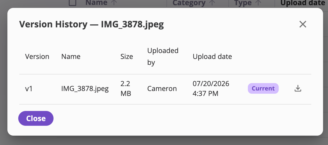 The Version History dialog for a file, listing versions v3, v2, v1 with Name, Size, Uploaded by, and Upload date columns, a Current badge on the newest version, and per-version download and restore icons.