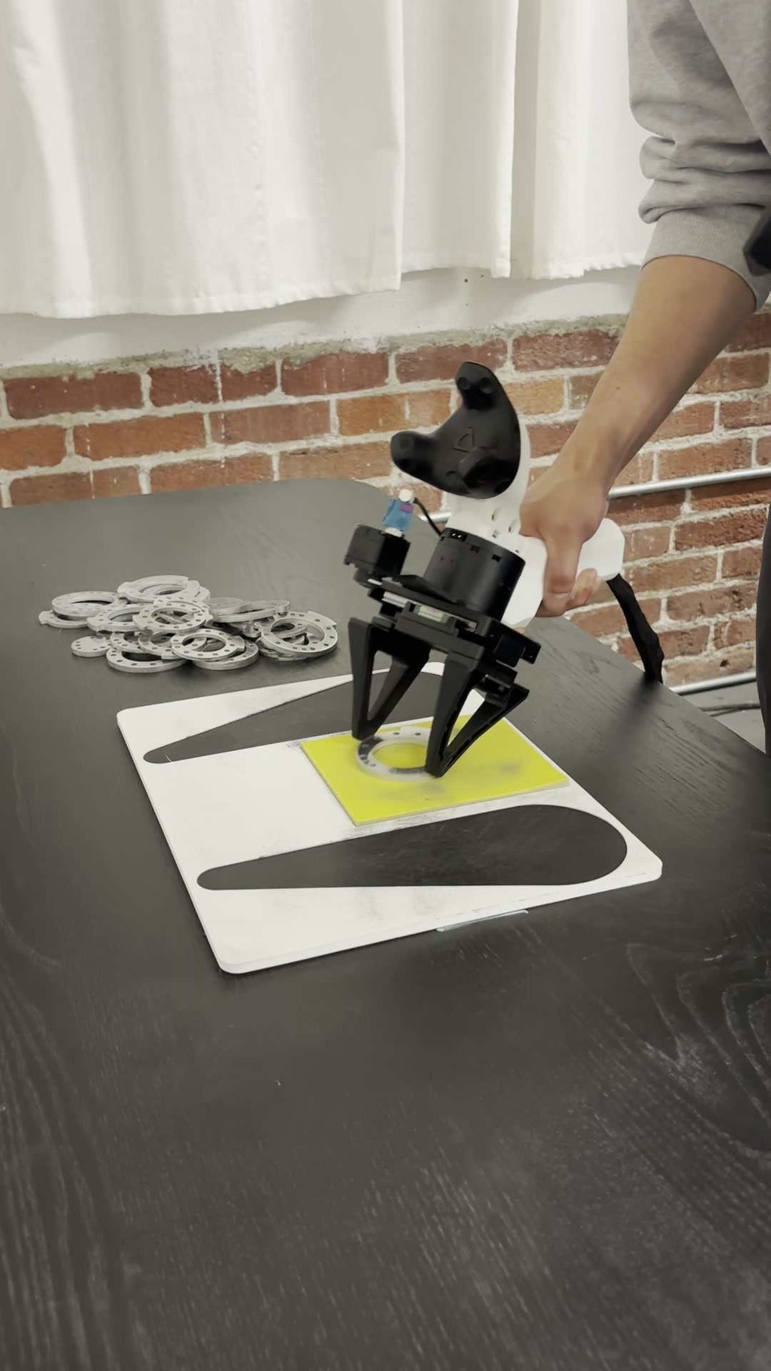 A Mantis rig grasping a part, with a VIVE Tracker 3.0 on the flat-back mount and a wrist camera fitted