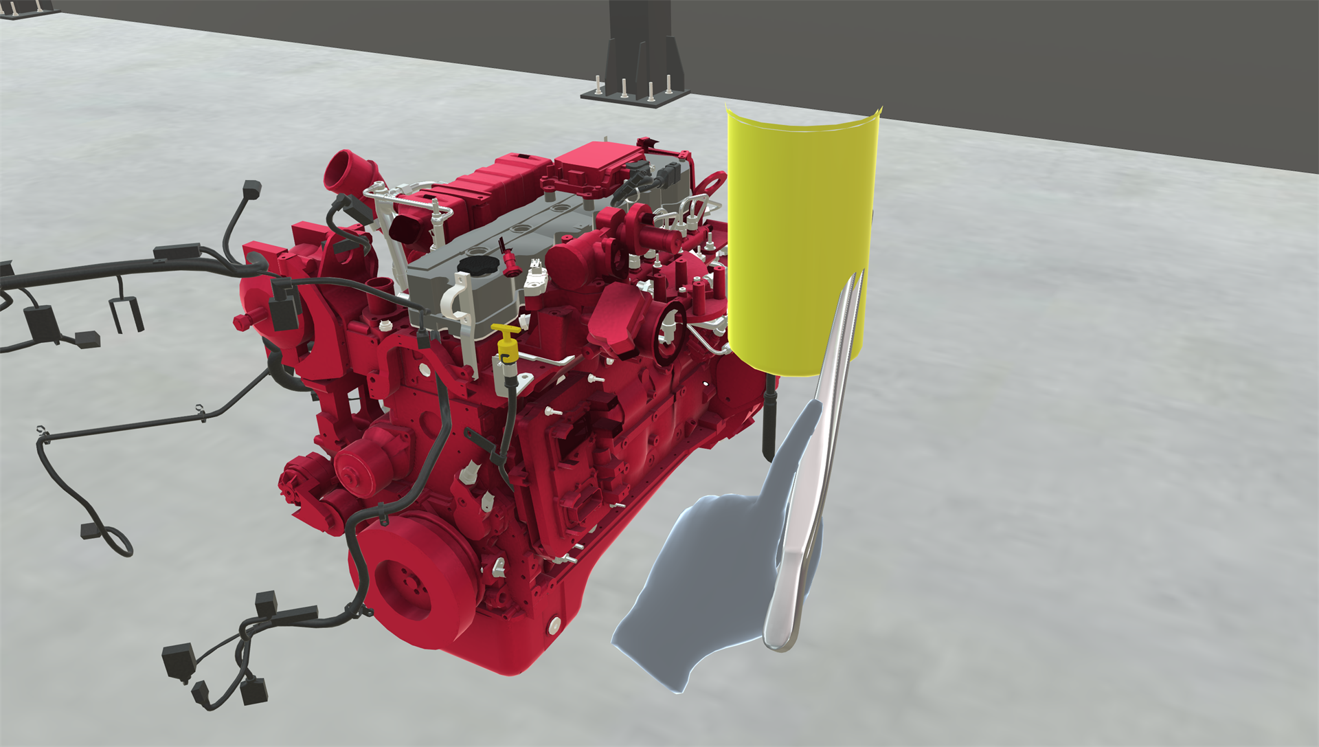 The trainee holding forceps in their hand next to an engine part