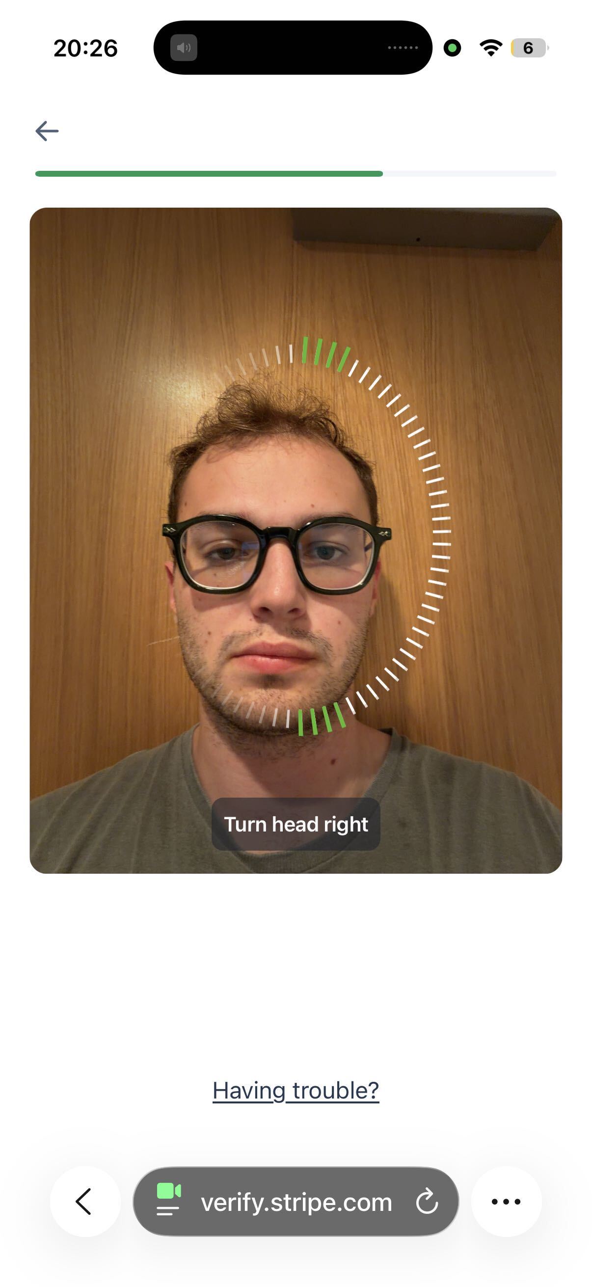 Phone screen guiding the candidate to turn their head while the liveness ring fills in