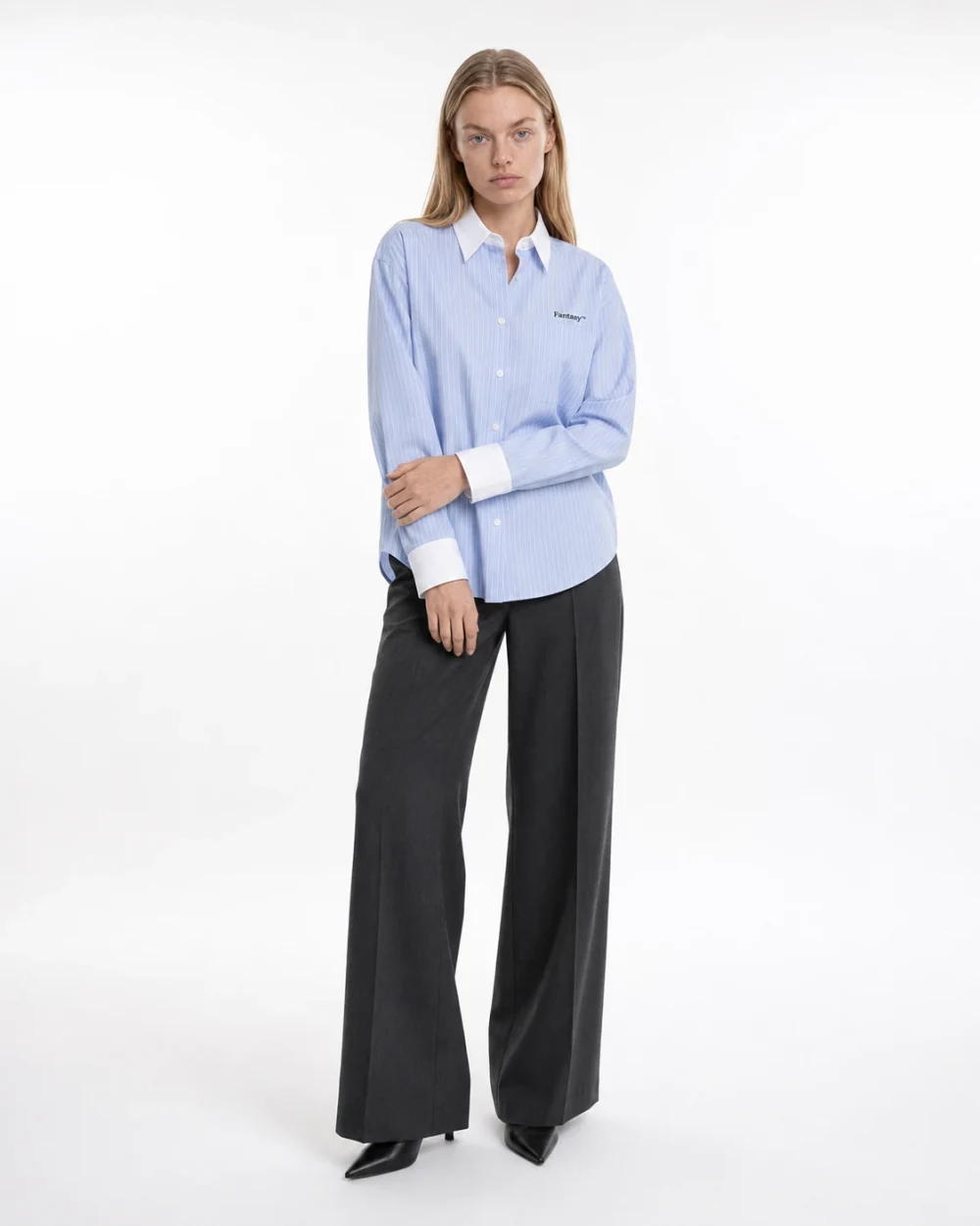 Full-length studio example of the blue striped shirt paired with dark trousers
