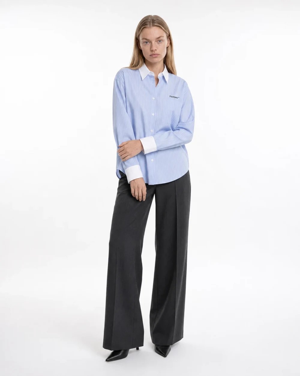 Full-length studio example of the blue striped shirt paired with dark trousers