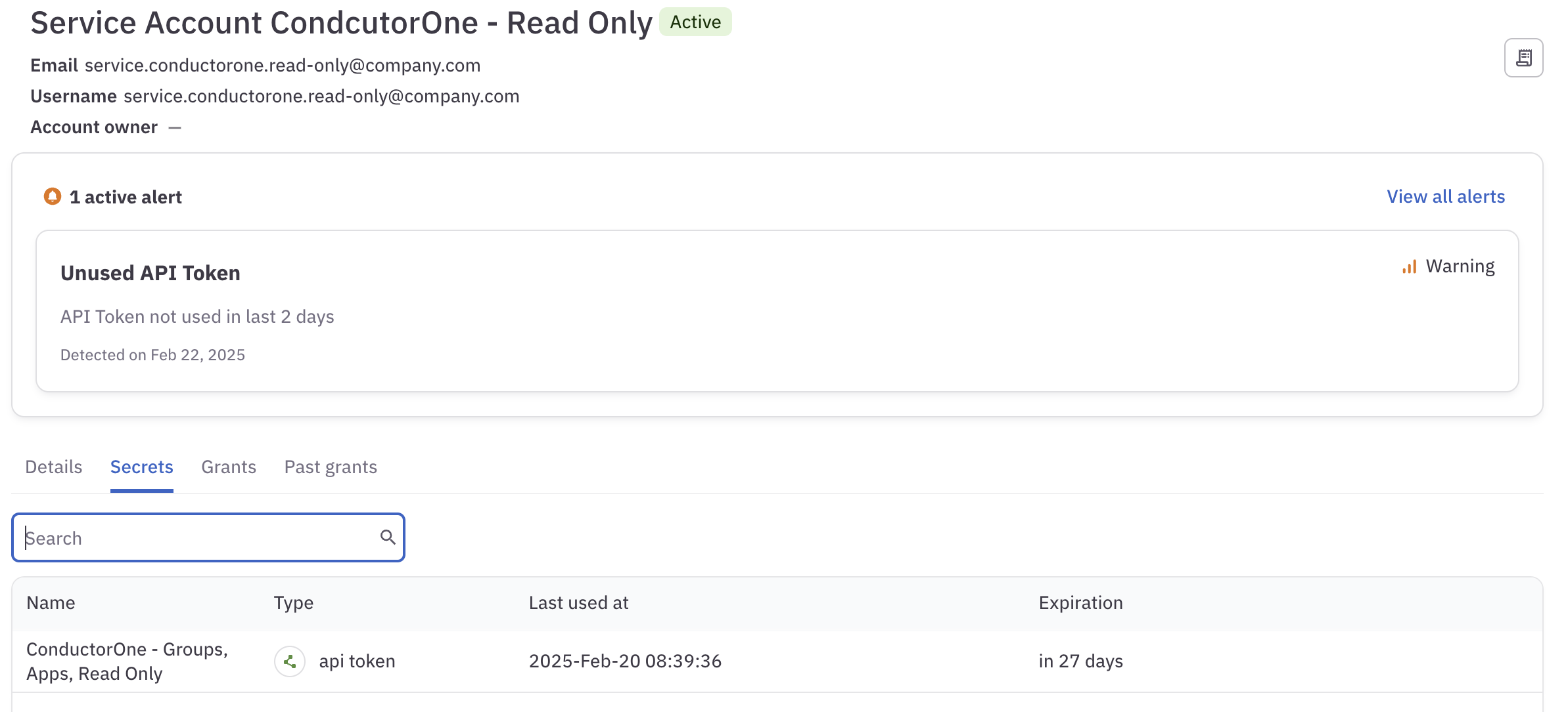 A screenshot of an identity's details page, showing one active alert for an API token that has not been used in two days.