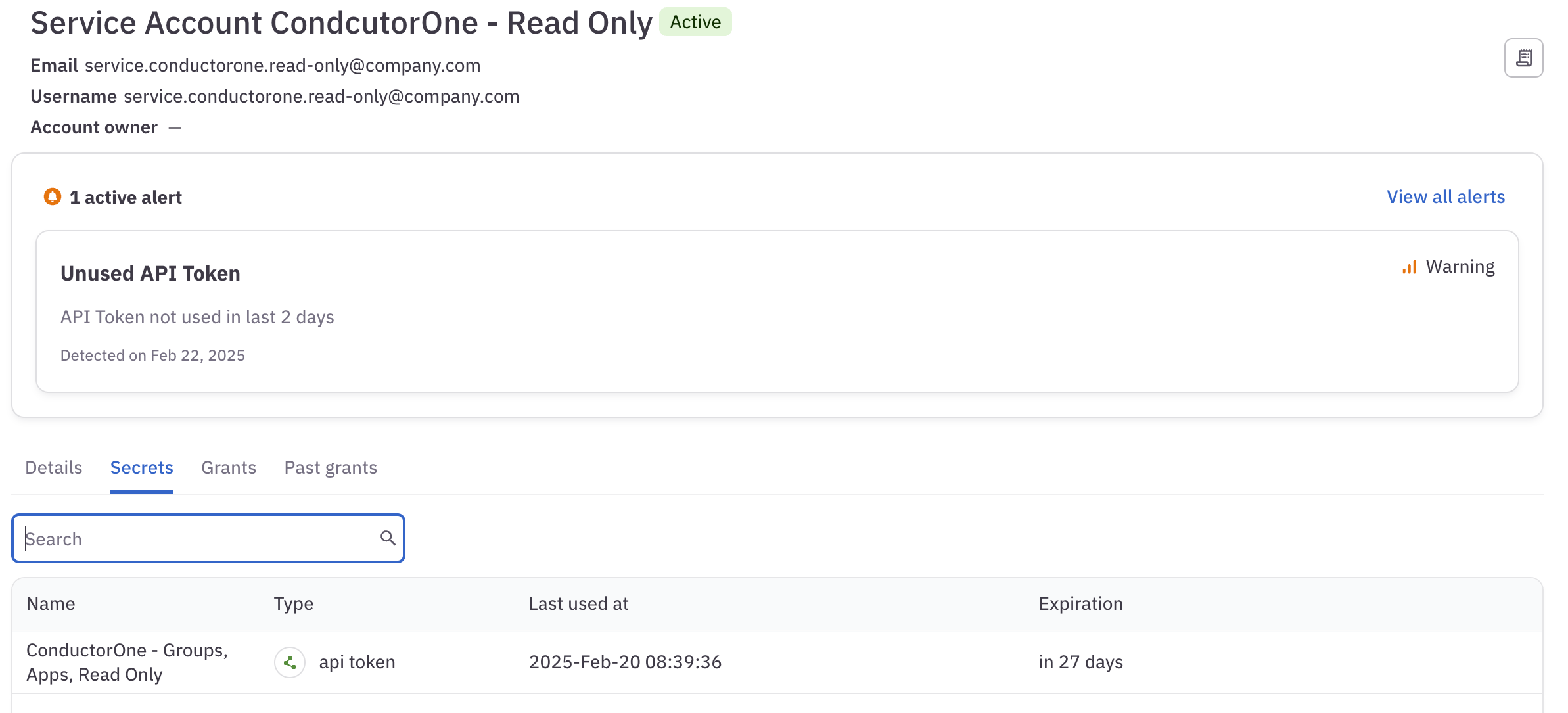 A screenshot of an identity's details page, showing one active alert for an API token that has not been used in two days.