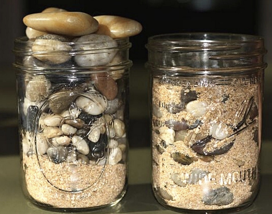 Two jars showing stones placed before sand and sand placed before stones