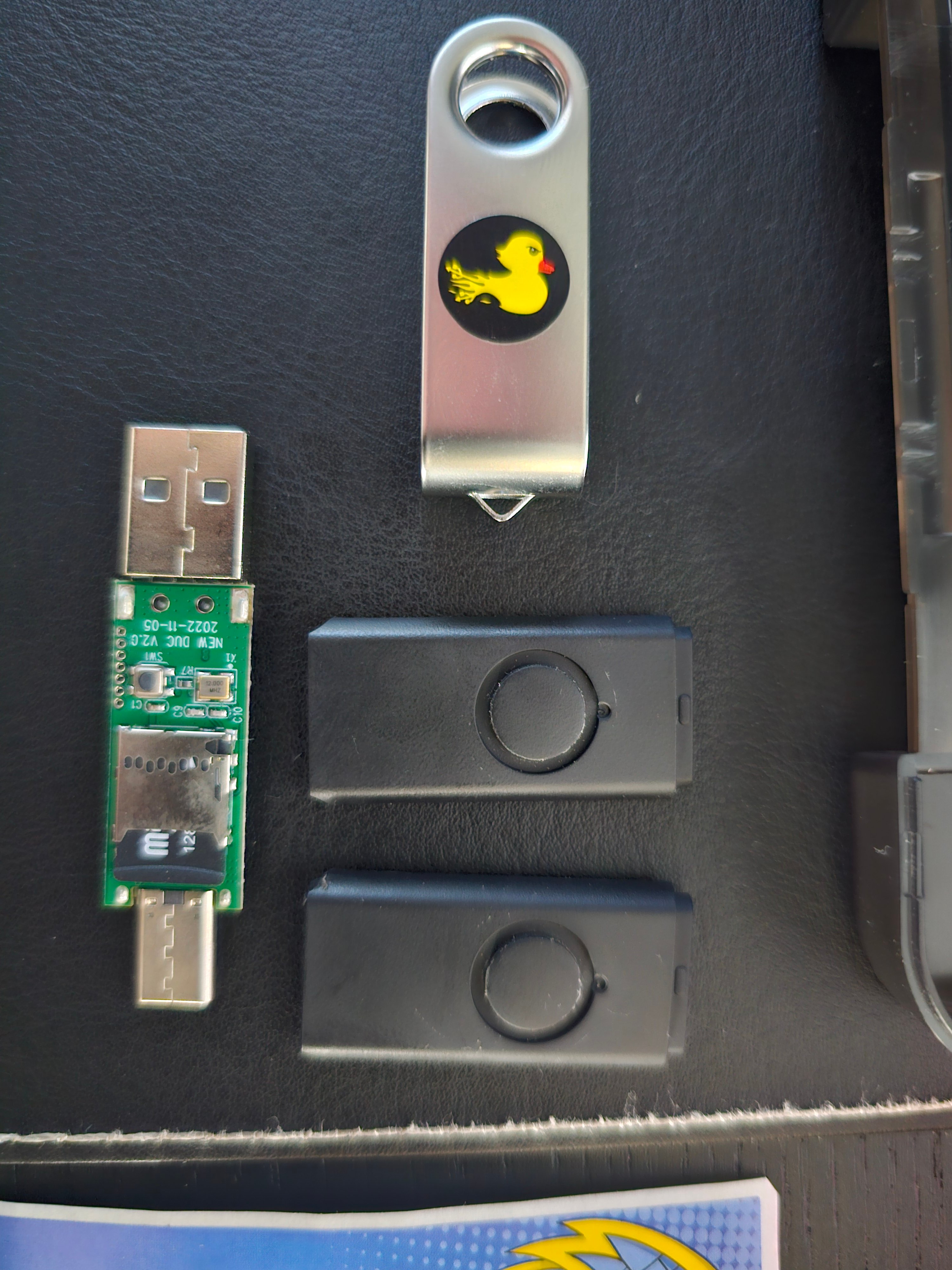 Multiple USB Rubber Ducky variants - the bare PCB, a branded unit with the duck logo, and two black-cased versions