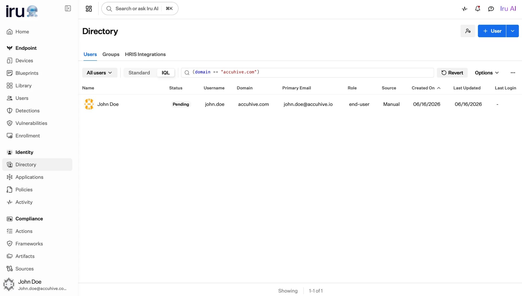 The Users list in IQL mode with the expression domain == accuhive.com in the search bar and a Revert button.