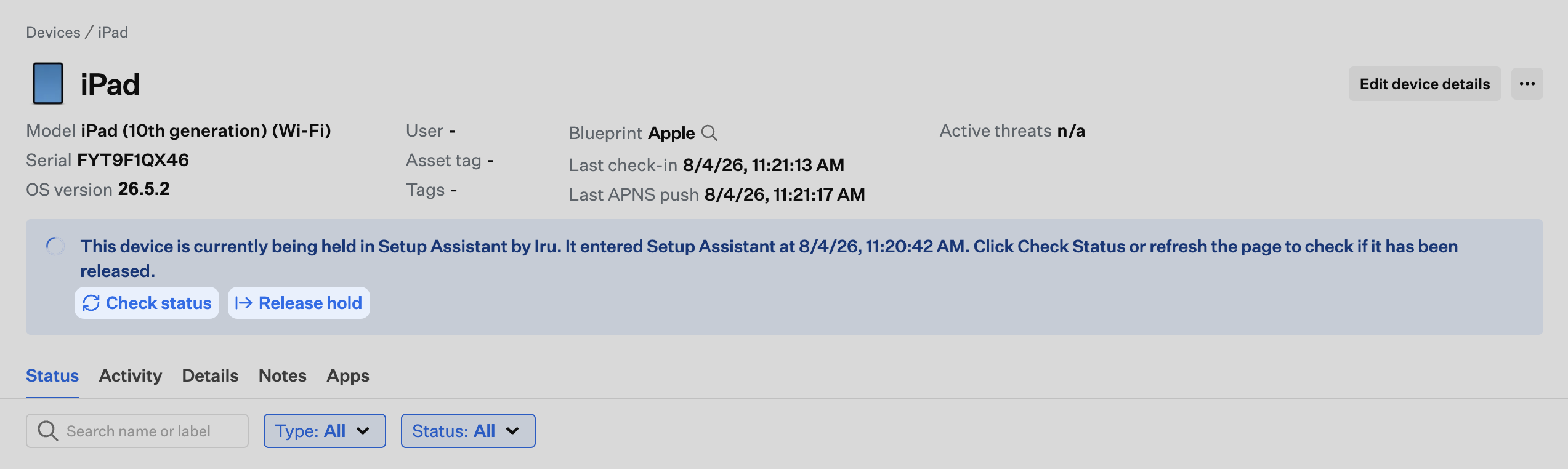 Device record banner showing the device is held in Setup Assistant with Check status and Release hold