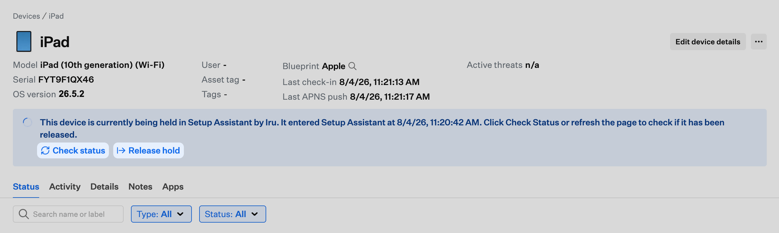 Device record banner showing the device is held in Setup Assistant with Check status and Release hold