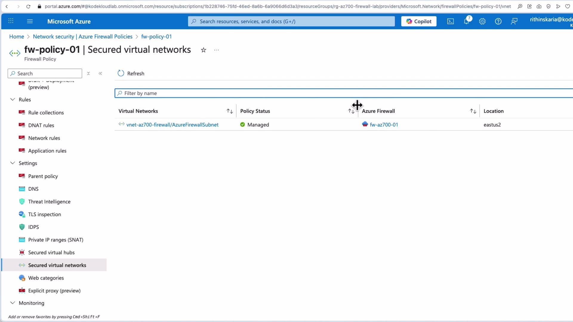 The image shows the Azure portal interface displaying details of a firewall policy named "fw-policy-01" and its associated secured virtual network. The policy status indicates it is managed, and it is linked to an Azure Firewall in the eastus2 location.