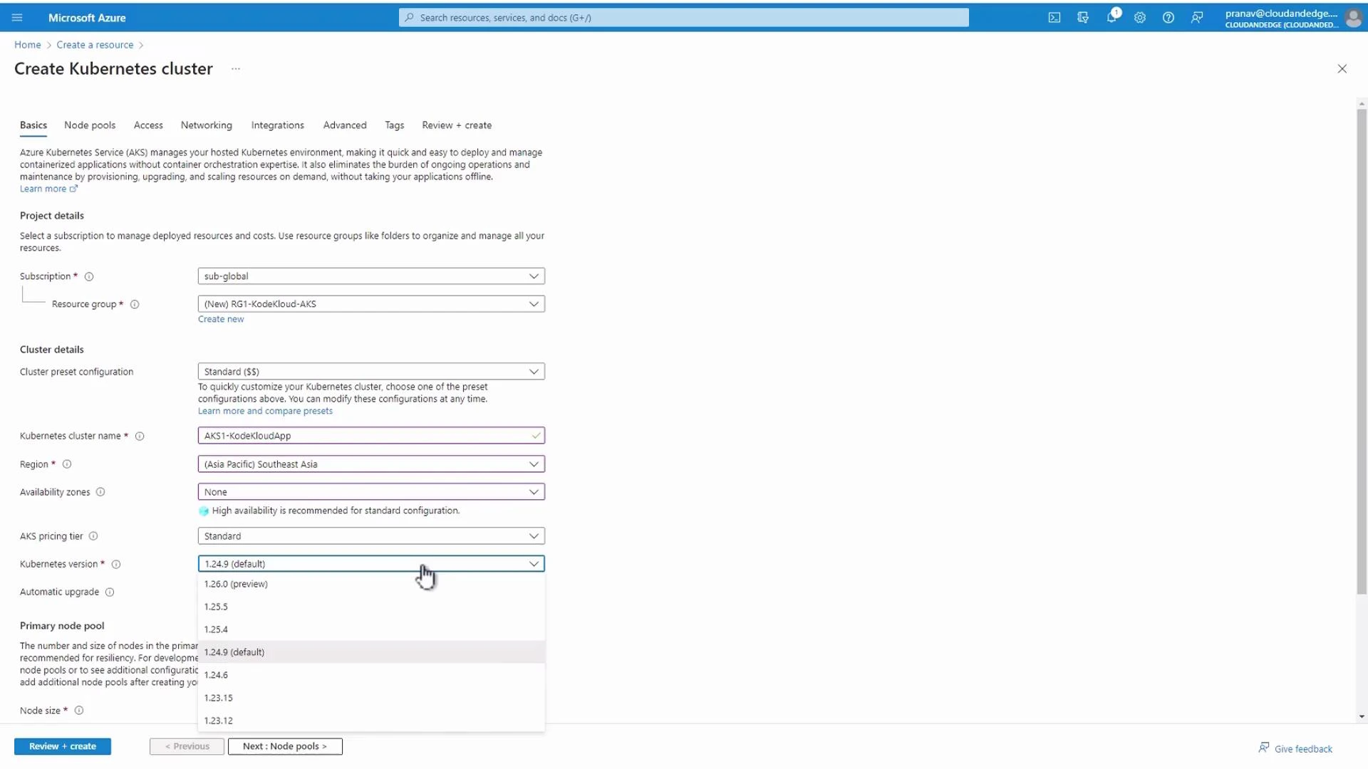A screenshot of the Microsoft Azure "Create Kubernetes cluster" wizard showing project and cluster details (subscription, resource group, region, cluster name, etc.). The Kubernetes version dropdown is open, listing available versions.