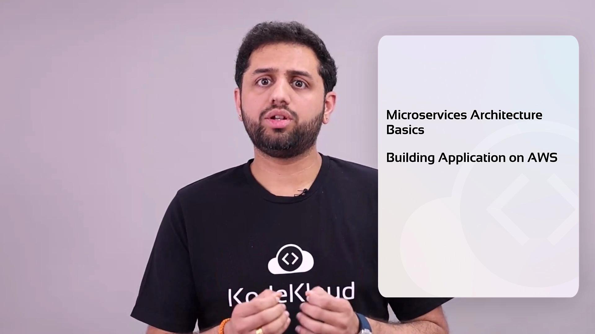The image shows a person speaking, wearing a black "KodeKloud" t-shirt, with text beside them listing "Microservices Architecture Basics" and "Building Application on AWS."