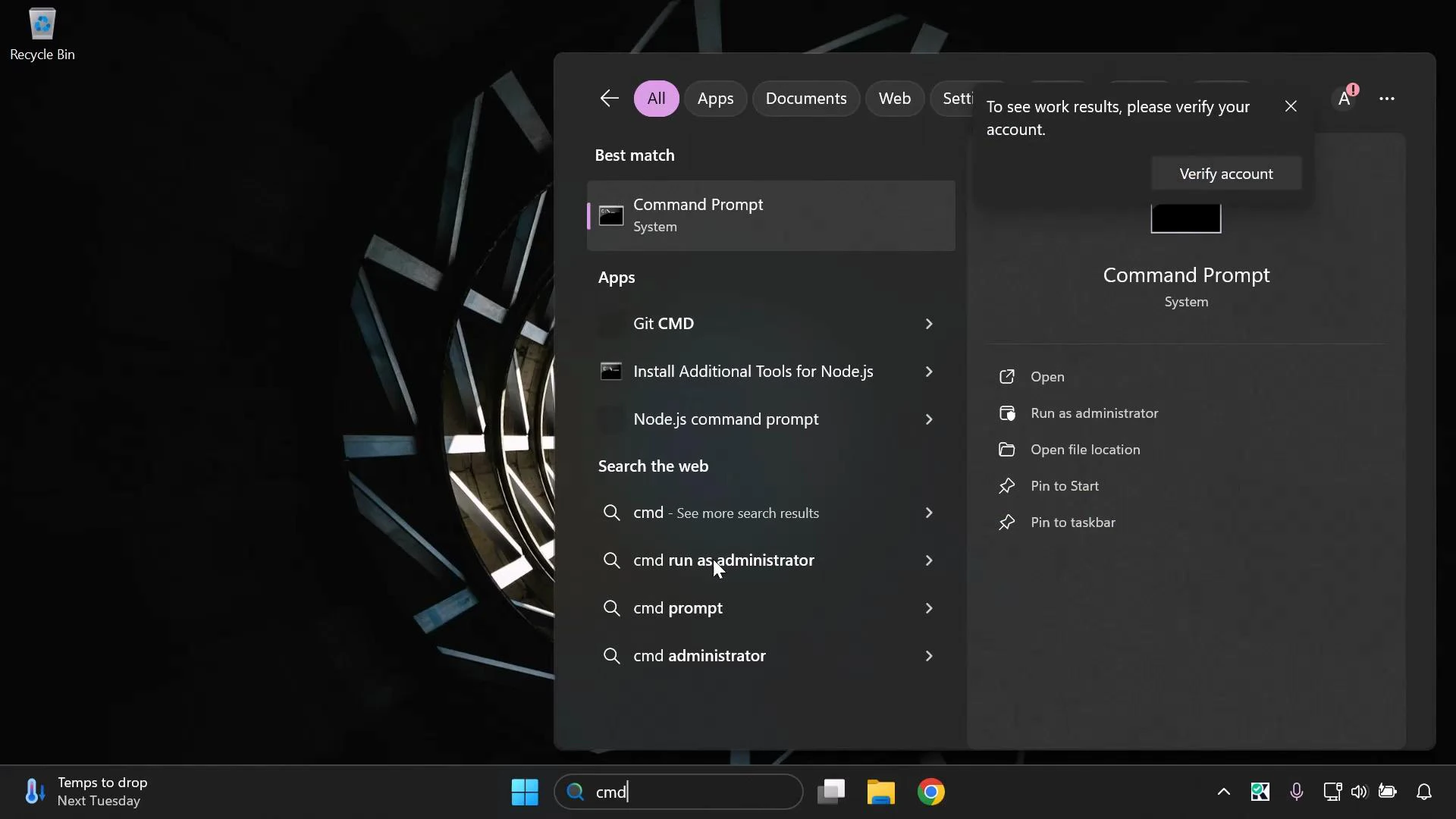 A Windows 11 desktop screenshot showing the Start/search panel with "Command Prompt" highlighted and several "cmd" search suggestions. A "Verify account" popup appears in the search pane, with Recycle Bin at the top-left and the taskbar along the bottom.