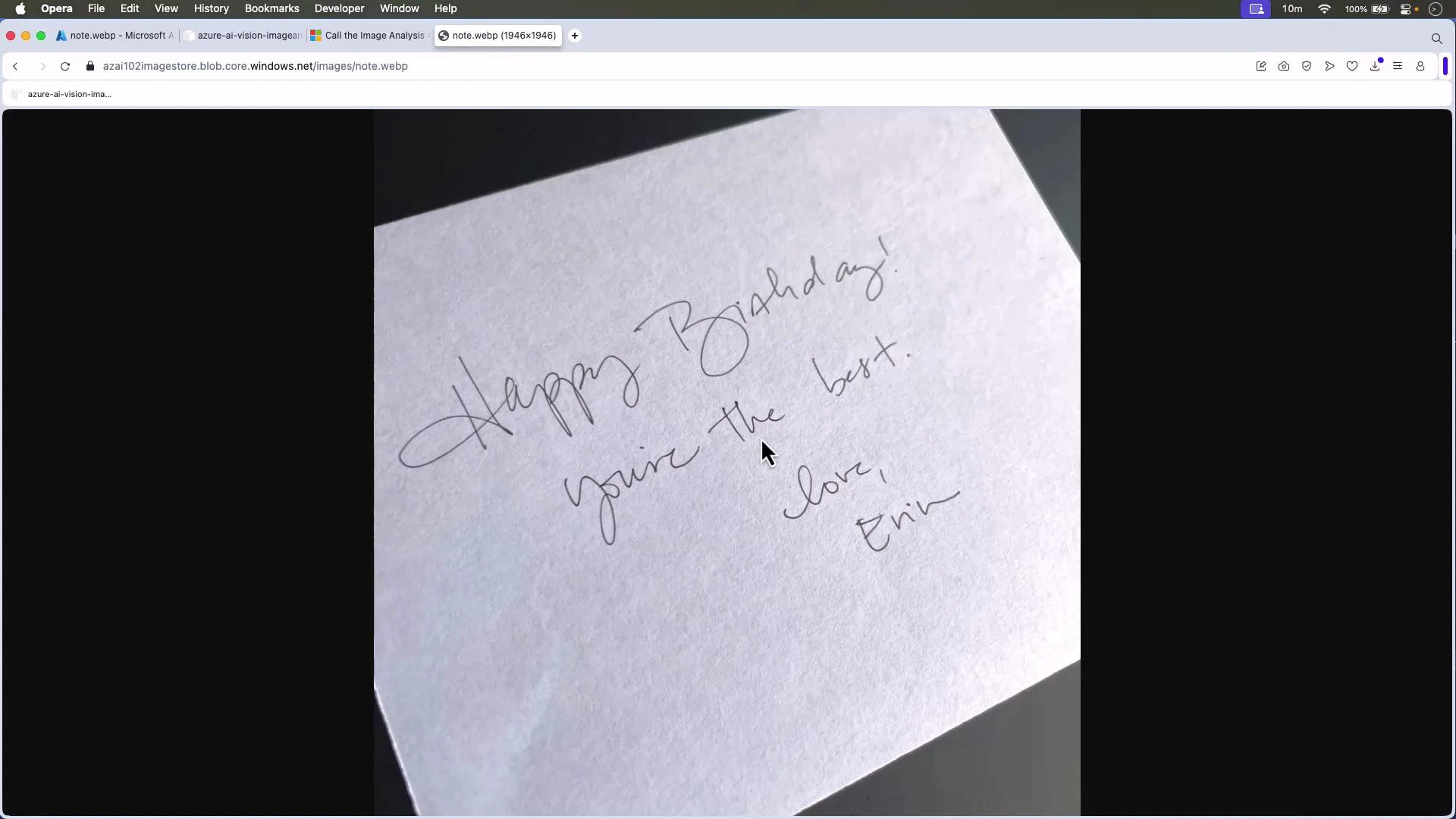 A handwritten birthday note on white paper that says, "Happy Birthday! You're the best. Love, Erin." The photo is taken at an angle and shows a cursor near the center.