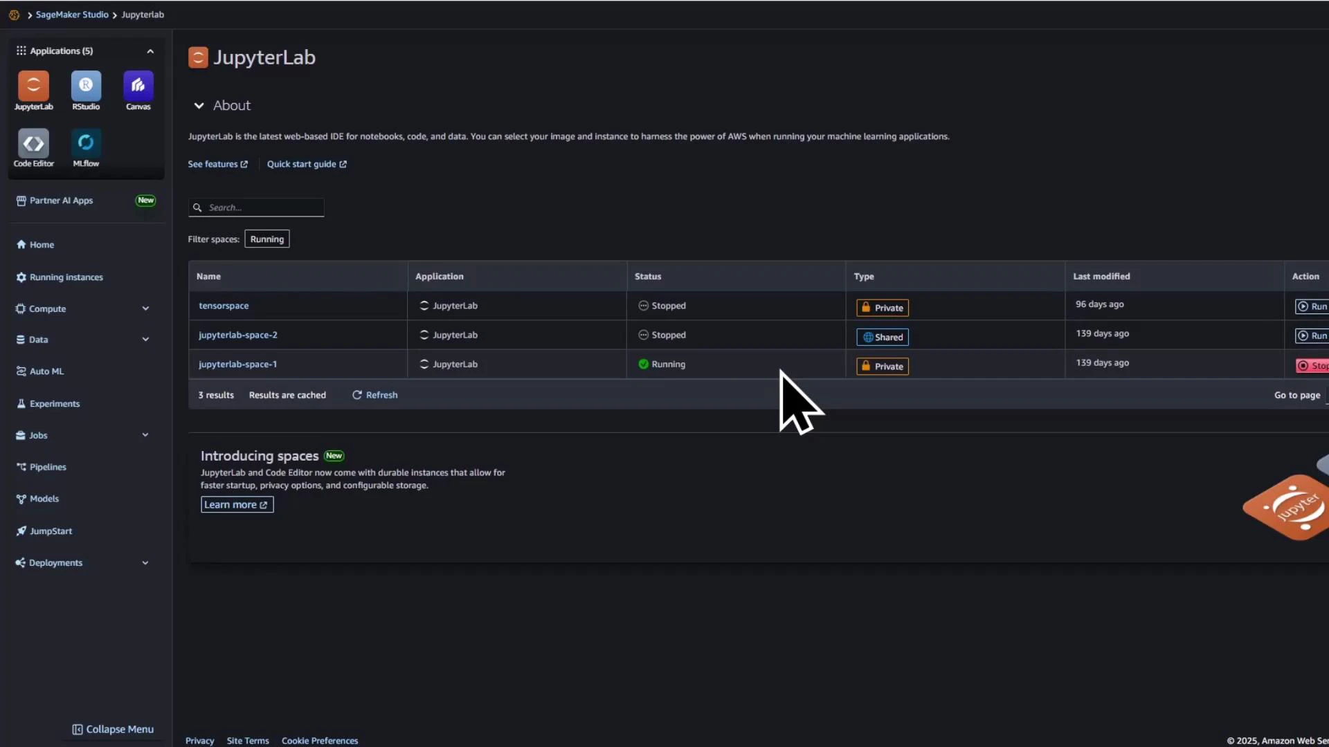 A screenshot of the AWS SageMaker Studio JupyterLab interface showing a table of three JupyterLab spaces/instances with their status (Stopped/Running), type (Private/Shared), and last-modified times. A large mouse cursor is visible over the list, and the left sidebar displays navigation items and apps.