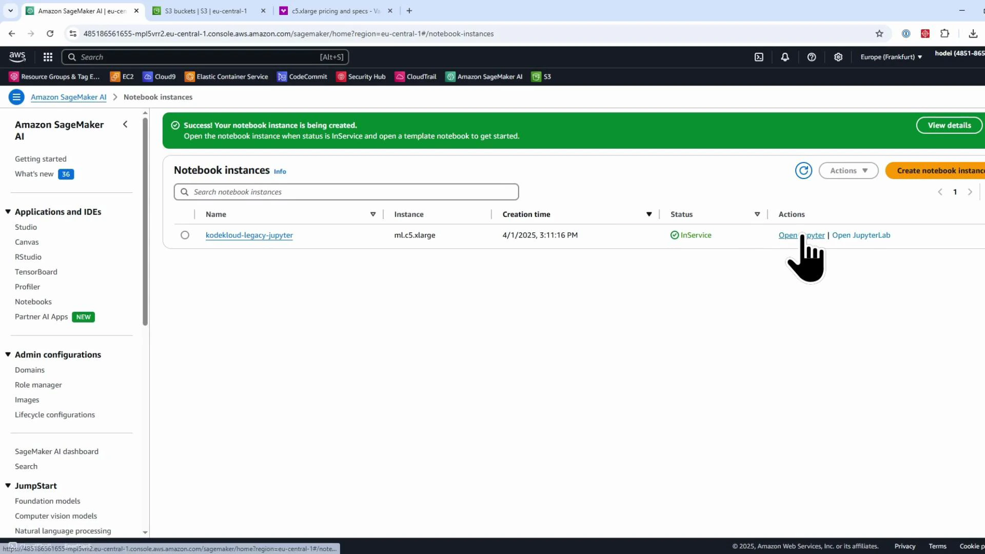 A screenshot of the Amazon SageMaker console showing the Notebook instances page with a green success banner and one notebook instance (kodekloud-legacy-jupyter) listed as InService. A hand-shaped cursor is hovering over the "Open Jupyter" action for that instance.