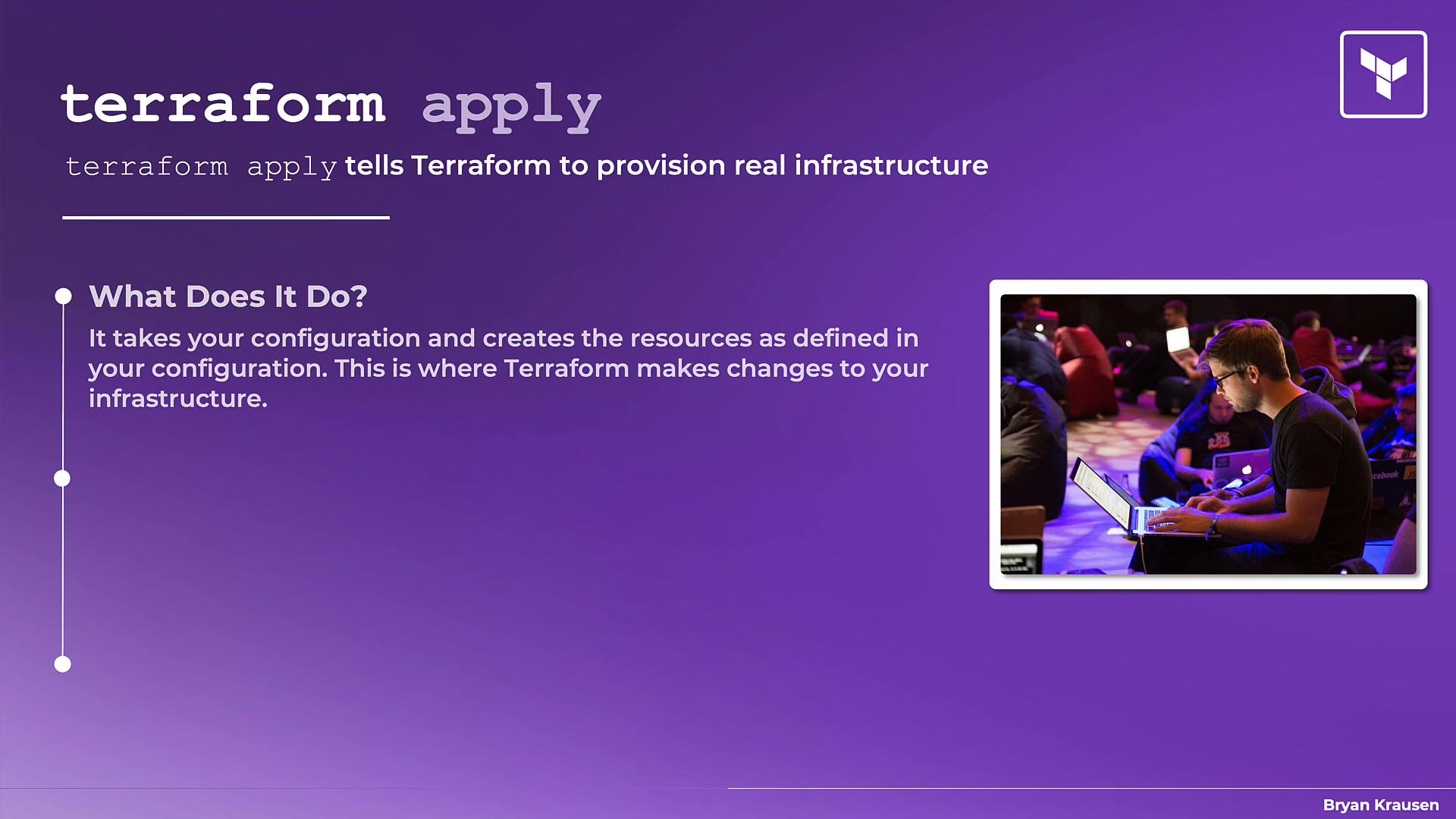 A purple presentation slide explaining the Terraform command "terraform apply," which provisions real infrastructure from your configuration. On the right is a photo of several people sitting and working on laptops.