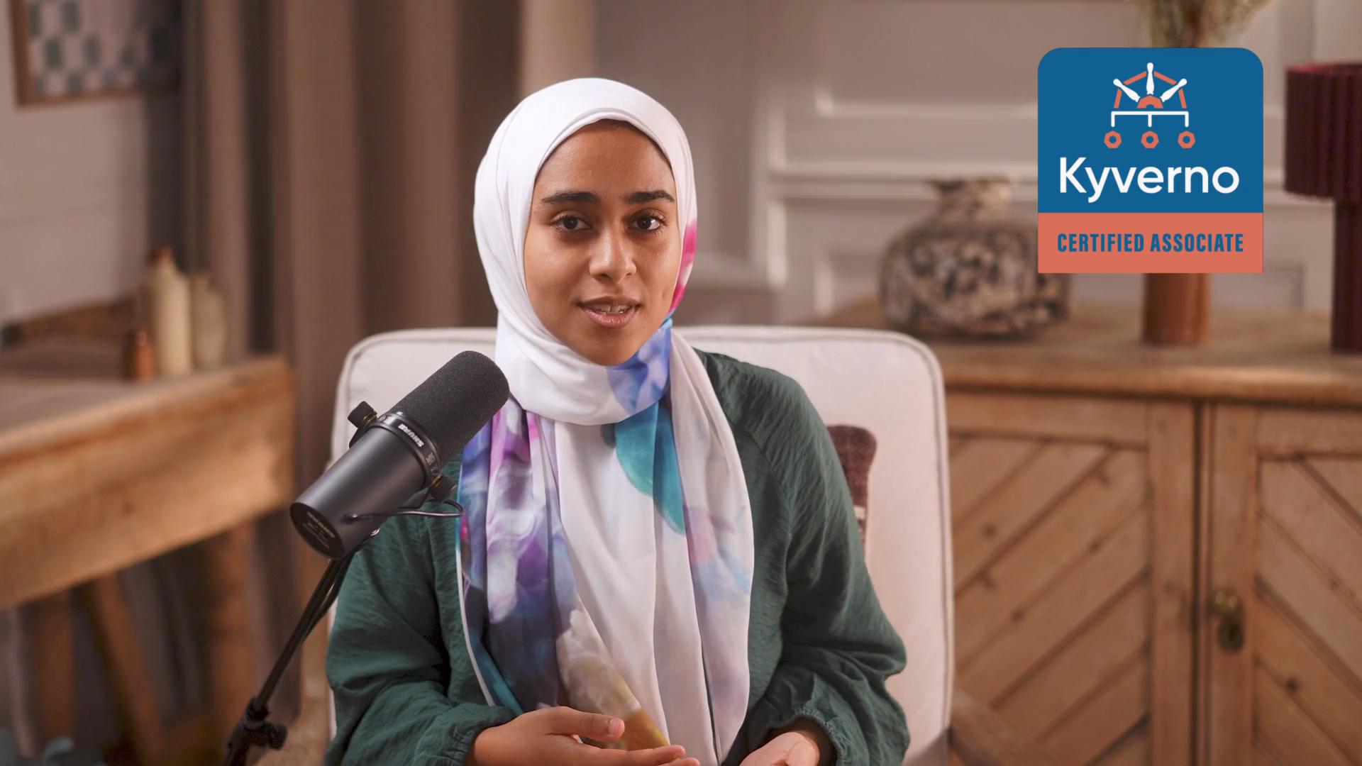 A woman wearing a hijab is speaking into a microphone, and there's a "Kyverno Certified Associate" badge overlayed on the image.