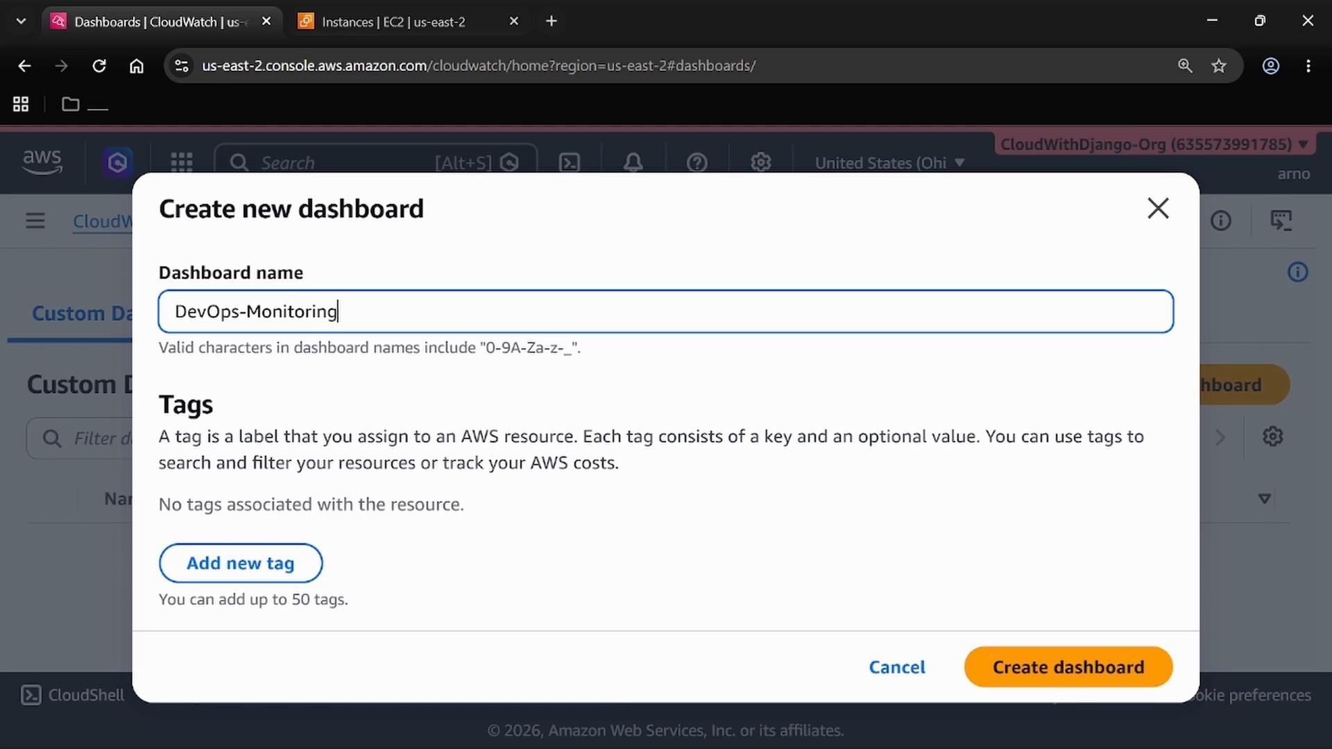 A screenshot of the AWS CloudWatch "Create new dashboard" dialog with the Dashboard name field filled as "DevOps-Monitoring", a Tags section, and a "Create dashboard" button. The AWS console and browser tabs are visible in the background.