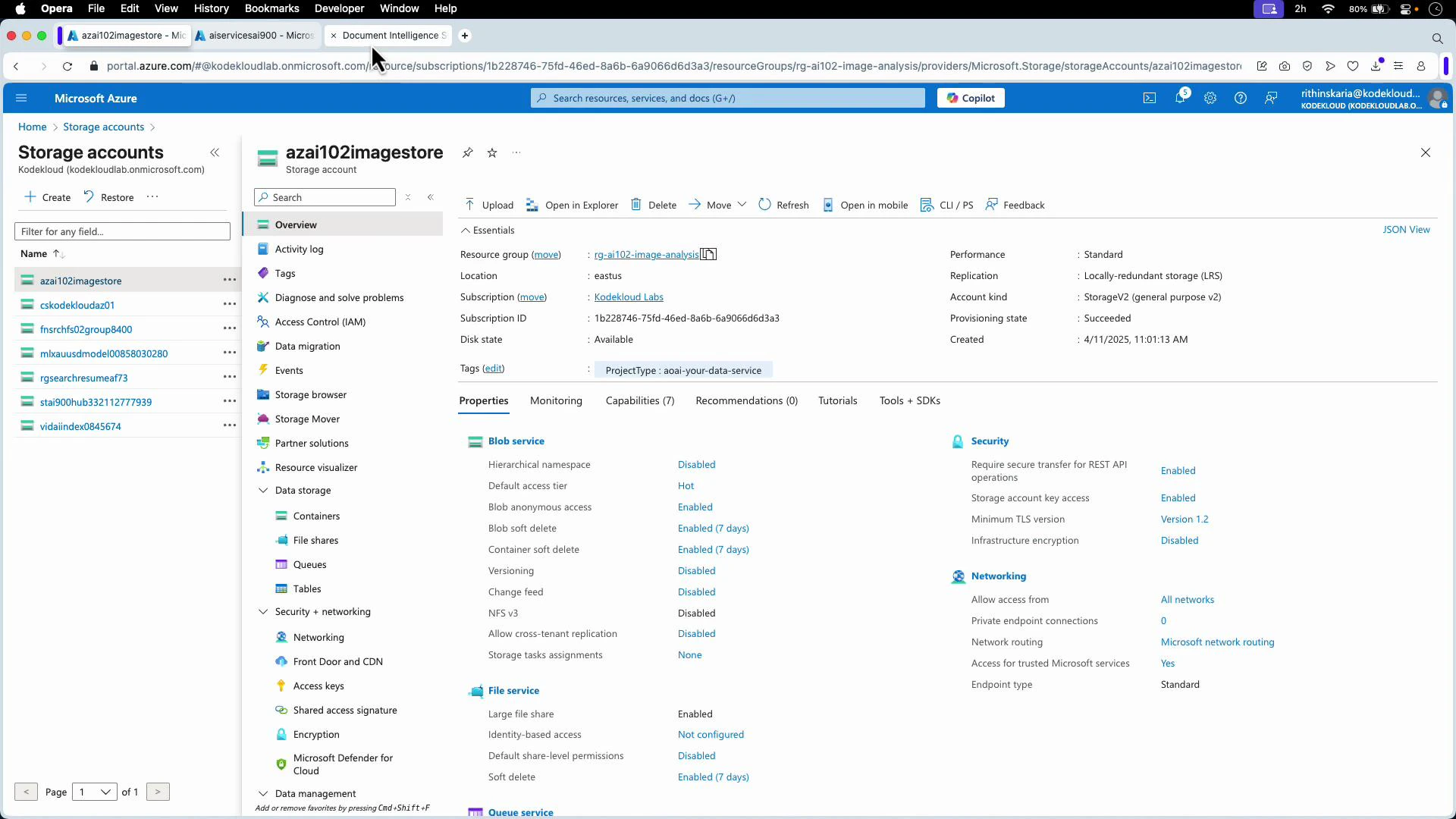 A screenshot of the Microsoft Azure portal open to a Storage accounts page, showing the storage account "azai102imagestore" with its overview, properties, security, and networking details. The left pane lists other storage accounts and navigation options like Containers, File shares, and Access keys.