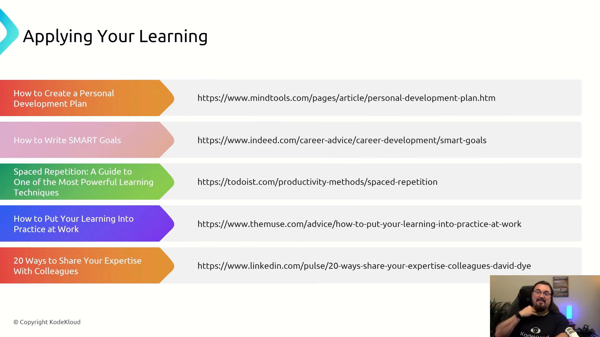 A presentation slide titled "Applying Your Learning" showing colored tabs with resource titles and URLs for personal development, SMART goals, spaced repetition, and sharing expertise. A small video feed of a man appears in the bottom-right corner.