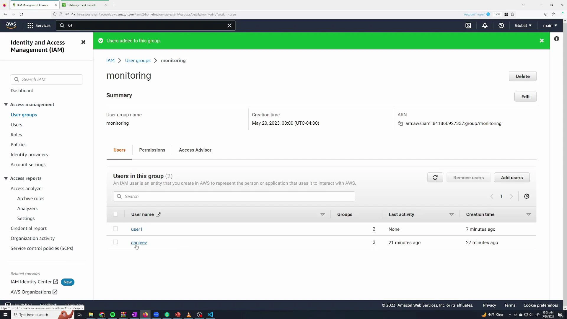 A screenshot of the AWS Identity and Access Management (IAM) console showing the "monitoring" user group summary with two users listed (user1 and sanjeev) and their last activity and creation times. The left sidebar shows IAM navigation and a green banner at the top indicates users were added to the group.