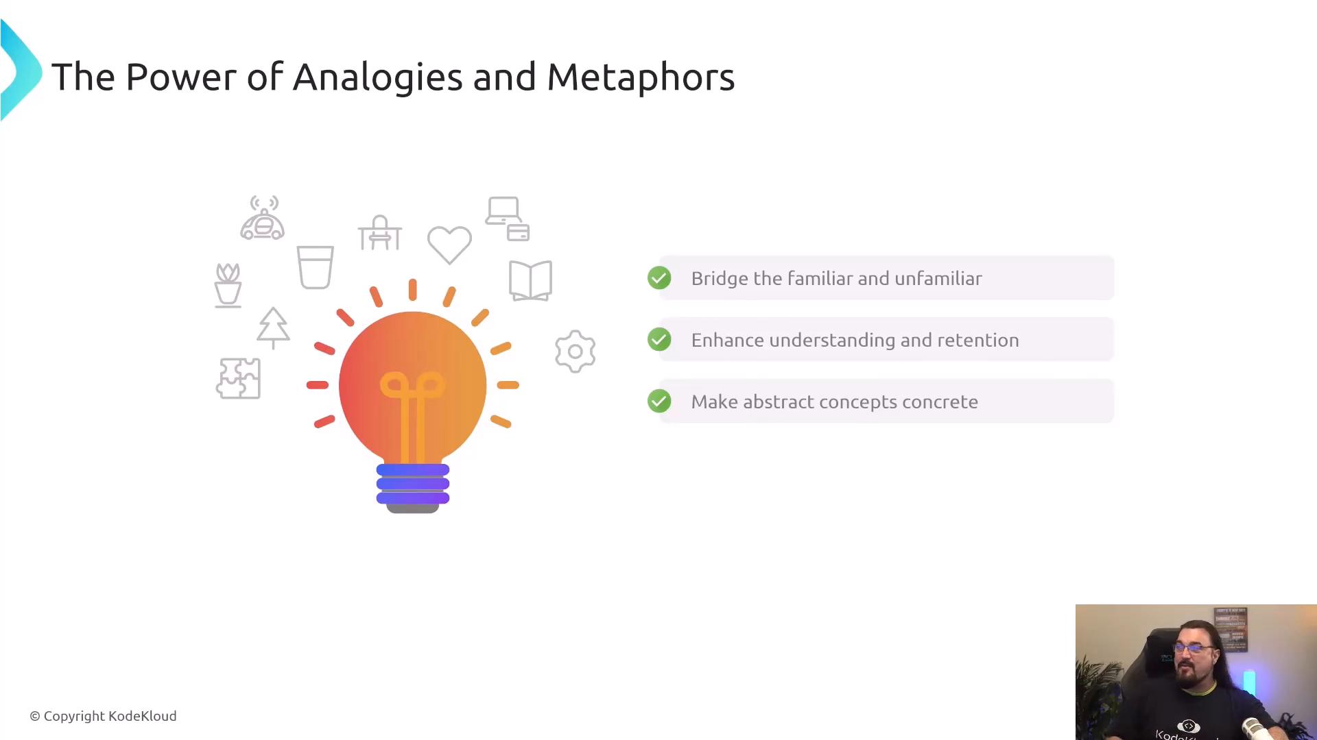 A presentation slide titled "The Power of Analogies and Metaphors" with a large colorful lightbulb graphic and three checkmarked points: "Bridge the familiar and unfamiliar," "Enhance understanding and retention," and "Make abstract concepts concrete." A small webcam feed of a presenter appears in the bottom-right corner.