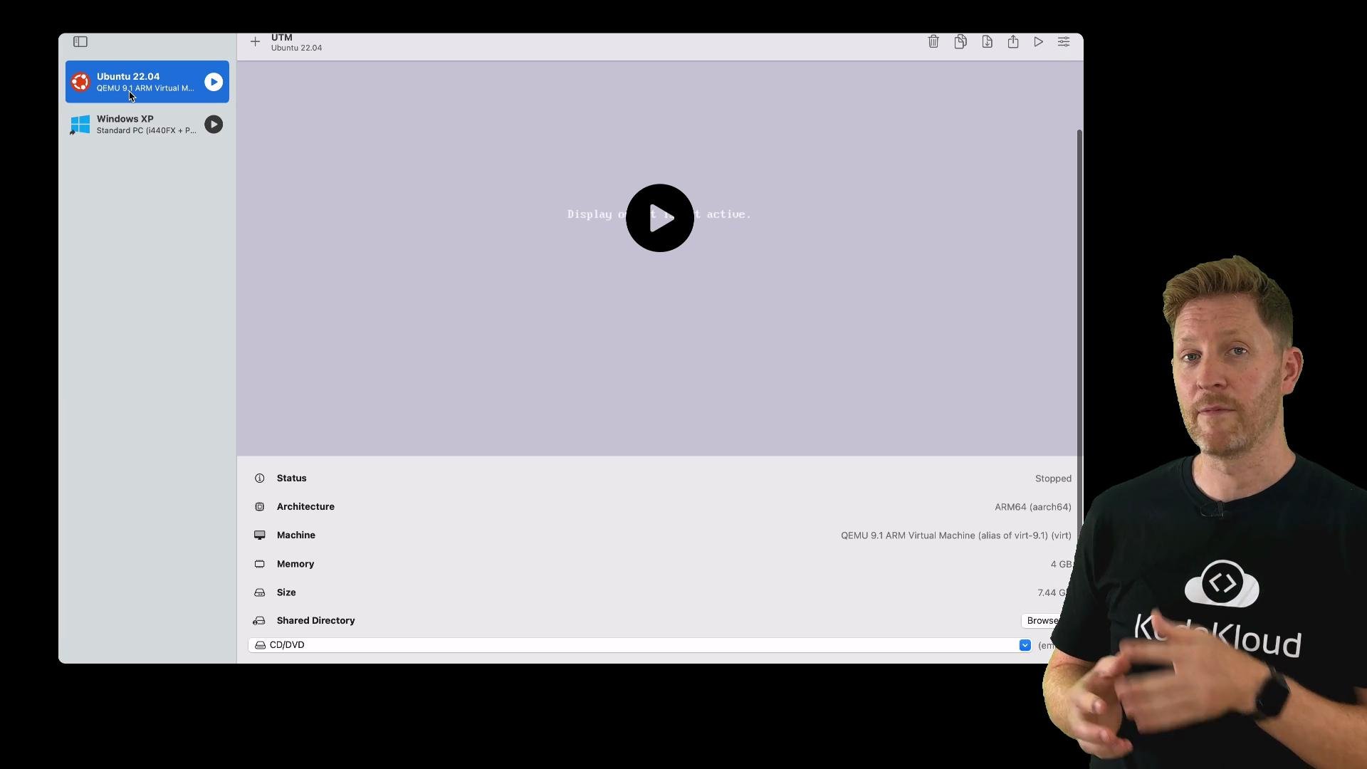 The image shows a virtual machine manager interface with options for Ubuntu 22.04 and Windows XP, and a person standing beside it.
