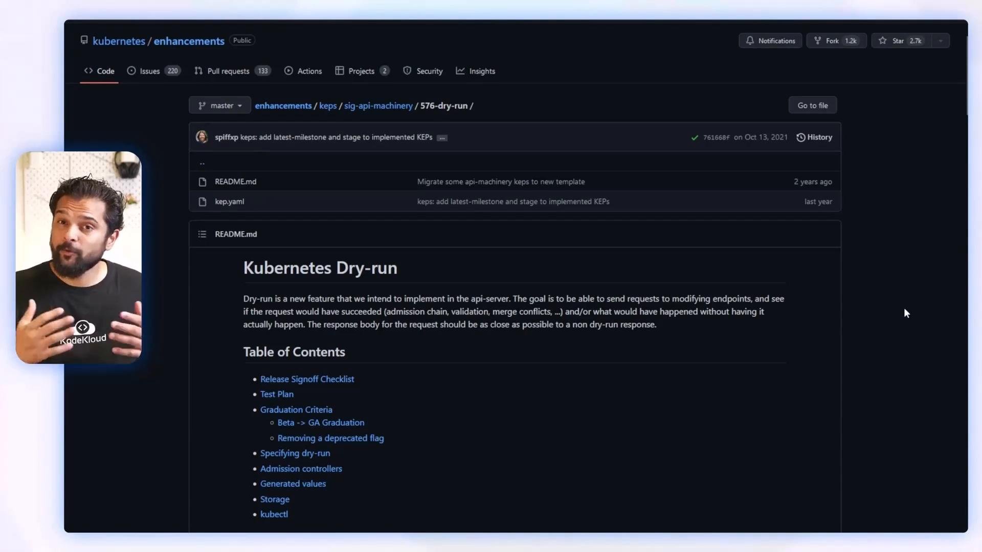 A dark-themed GitHub repository page open to a "Kubernetes Dry-run" README with a table of contents. A small inset video of a man speaking appears on the left.