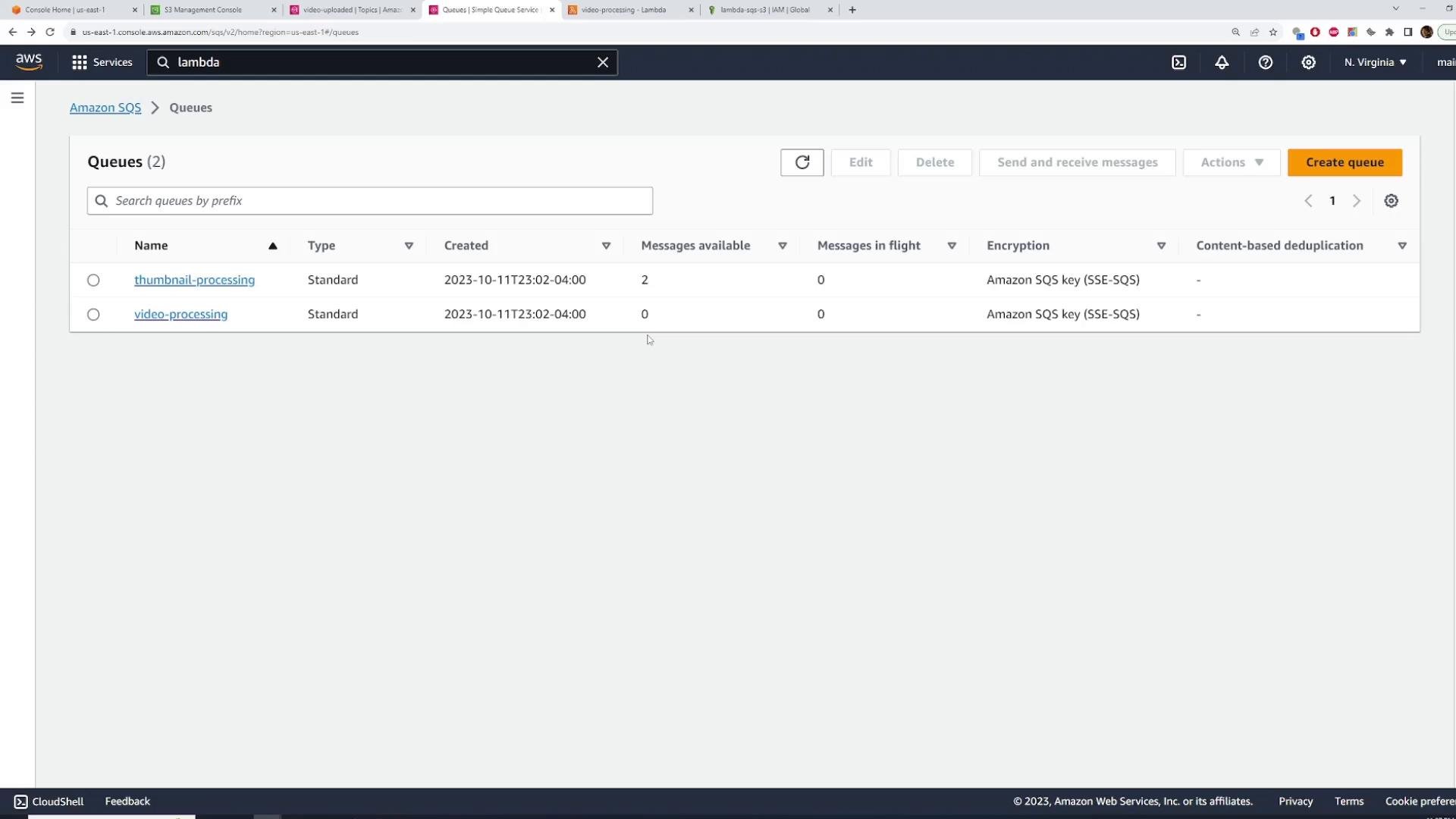 A screenshot of the AWS Amazon SQS console showing two queues — "thumbnail-processing" (2 messages available) and "video-processing" (0 messages) — with type, creation time, and encryption details. Browser tabs and the AWS top navigation bar are visible at the top.