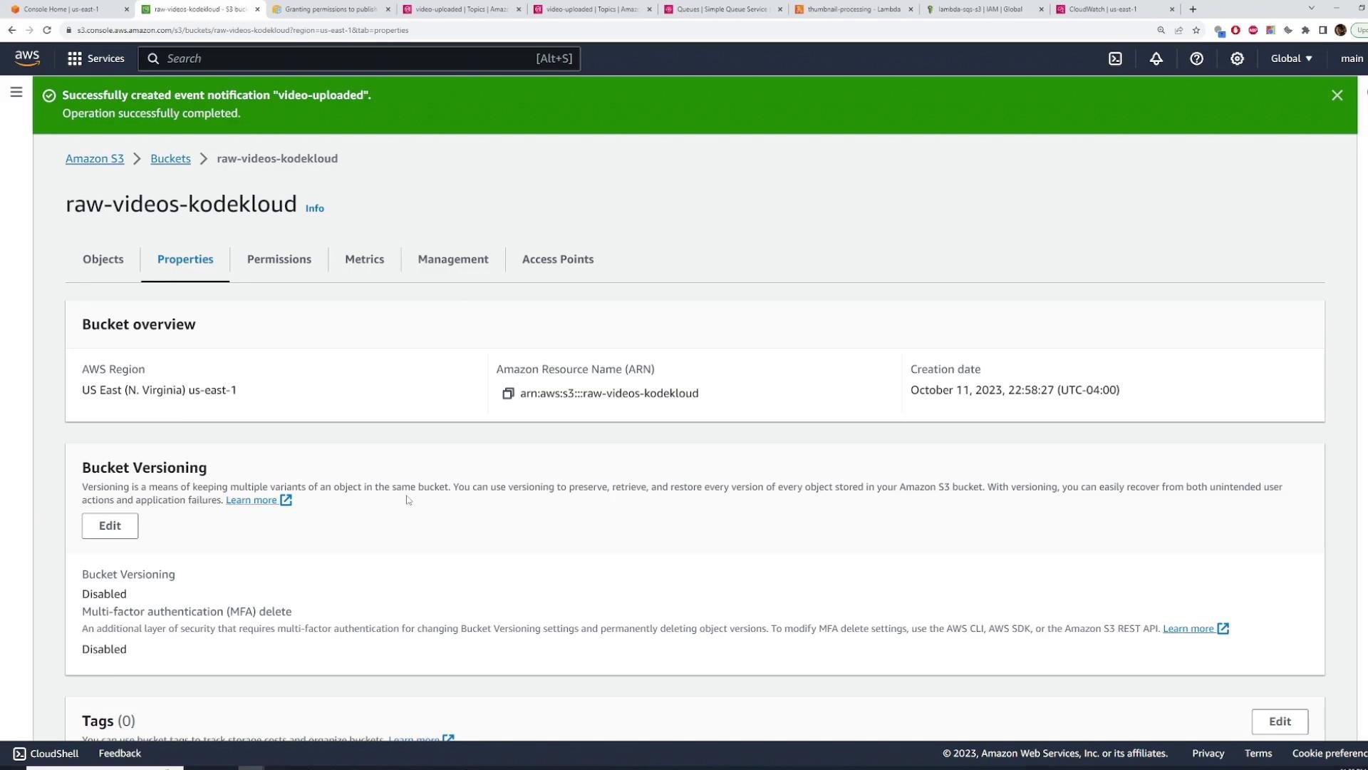 A screenshot of the AWS S3 console showing the Properties tab for an S3 bucket named "raw-videos-kodekloud" with bucket overview details (region, ARN, creation date) and a green success banner about a created event notification.