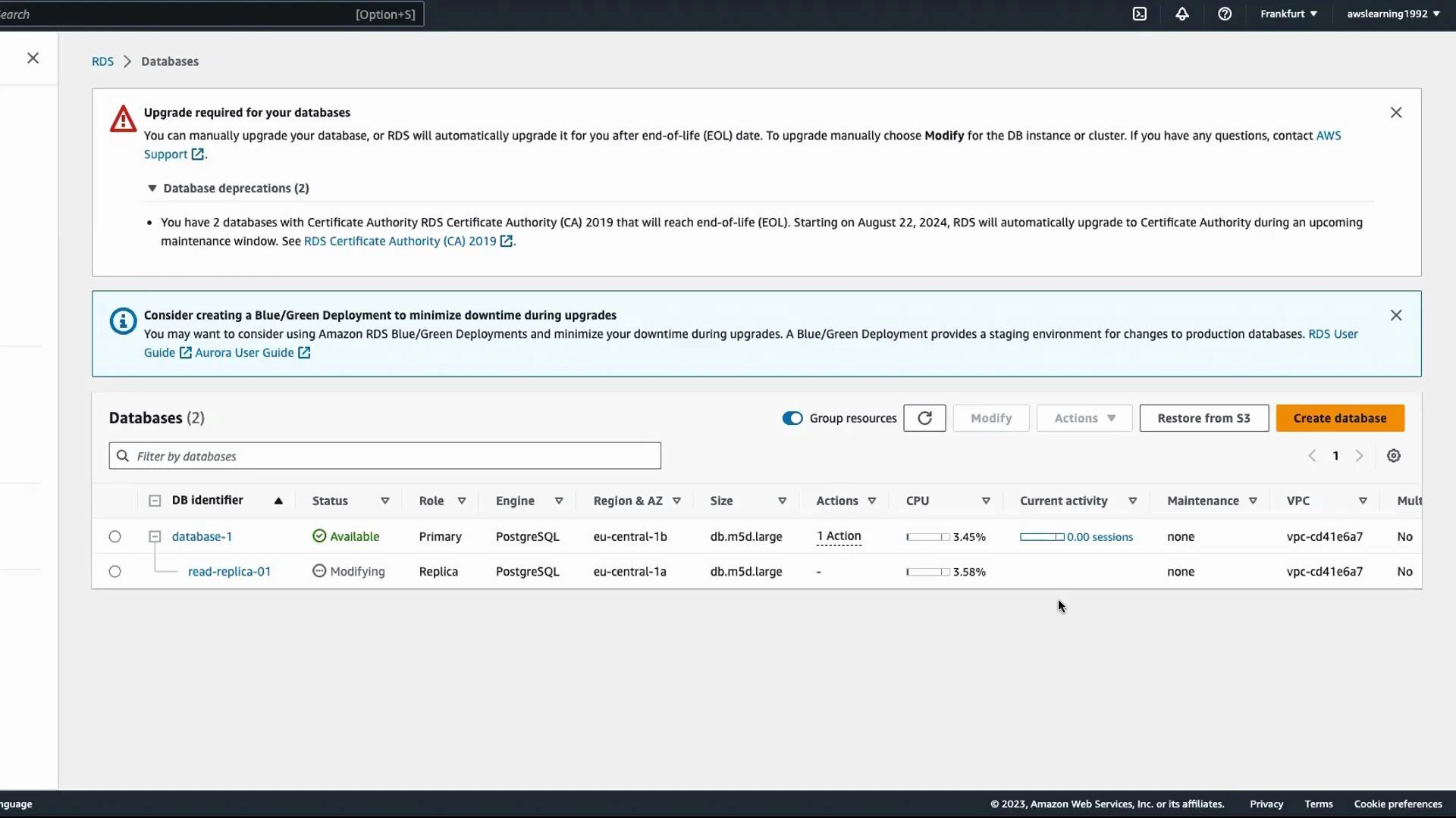 A screenshot of the AWS RDS Databases console showing upgrade/deprecation warnings and a Blue/Green deployment suggestion. The database table lists two PostgreSQL instances: "database-1" (Available, Primary) and "read-replica-01" (Modifying, Replica).