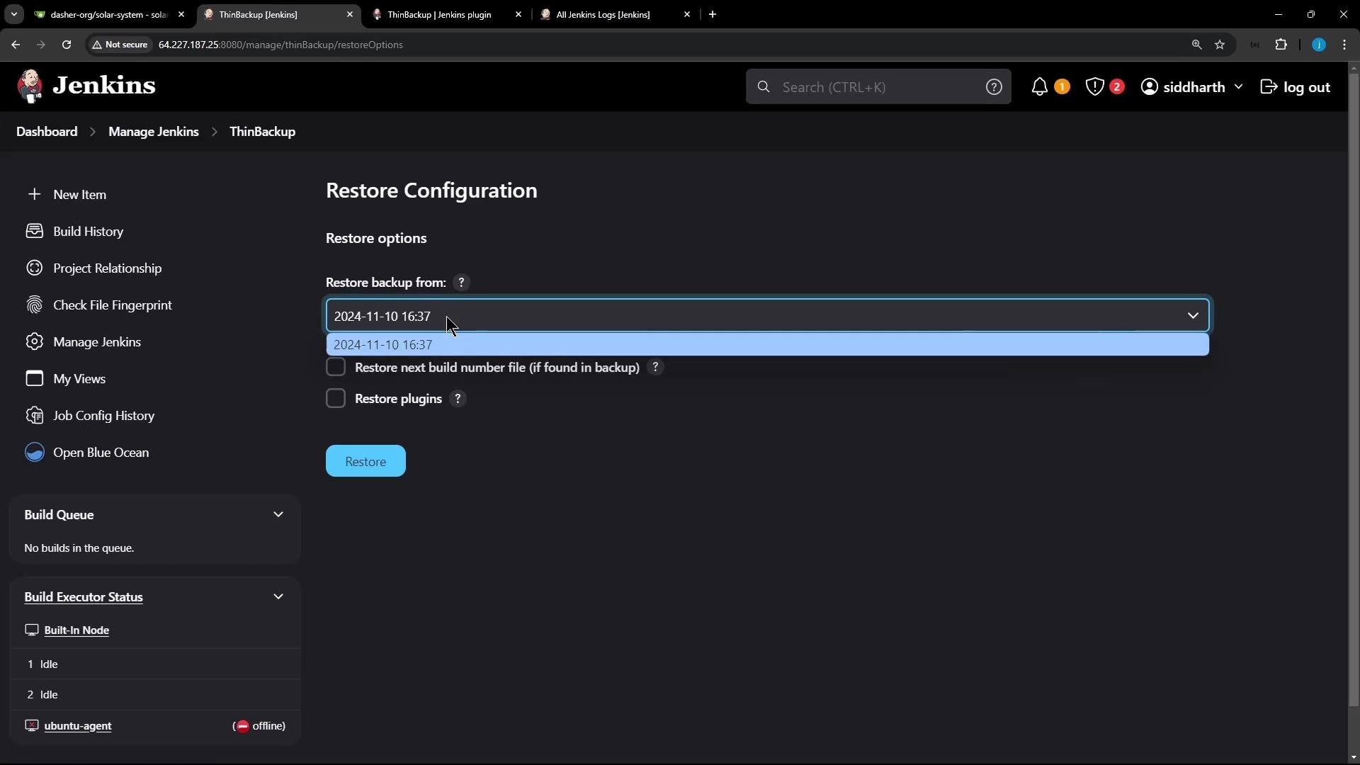 A screenshot of the Jenkins web UI showing the "Restore Configuration" page from the ThinBackup plugin, with a dropdown to select a backup date (2024-11-10 16:37) and checkboxes to restore the next build number file and plugins. The Jenkins sidebar and build/executor status widgets are visible on the left.