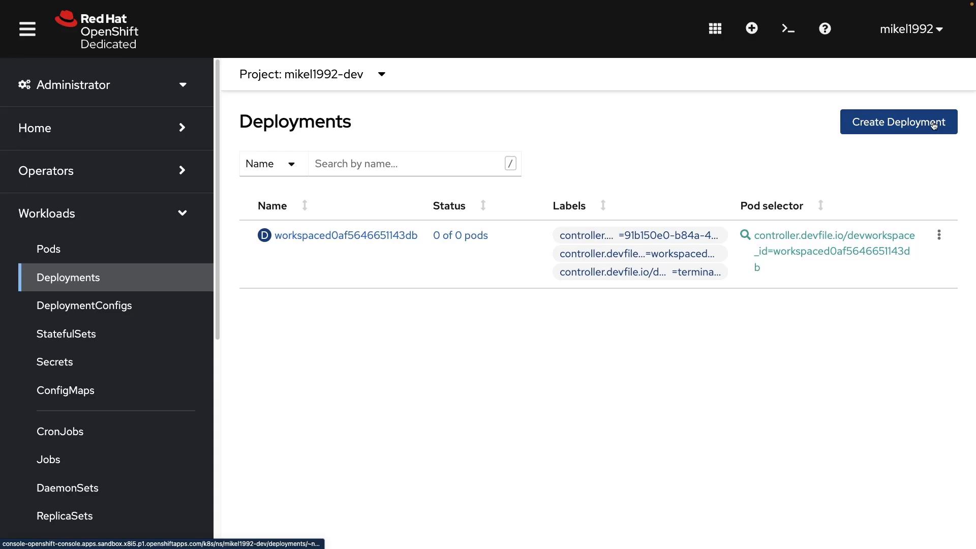 Screenshot of the Red Hat OpenShift Dedicated web console displaying a project's "Deployments" page. It shows one deployment entry with 0 pods, label and pod-selector info, a "Create Deployment" button, and the left-hand navigation menu.