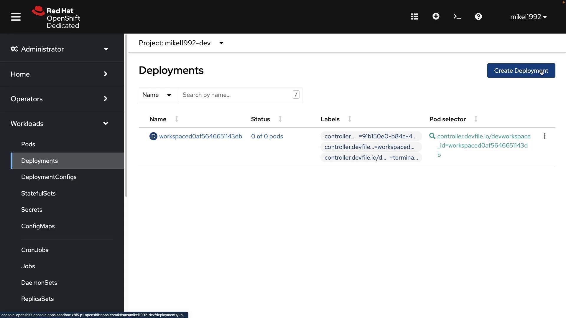 Screenshot of the Red Hat OpenShift Dedicated web console displaying a project's "Deployments" page. It shows one deployment entry with 0 pods, label and pod-selector info, a "Create Deployment" button, and the left-hand navigation menu.