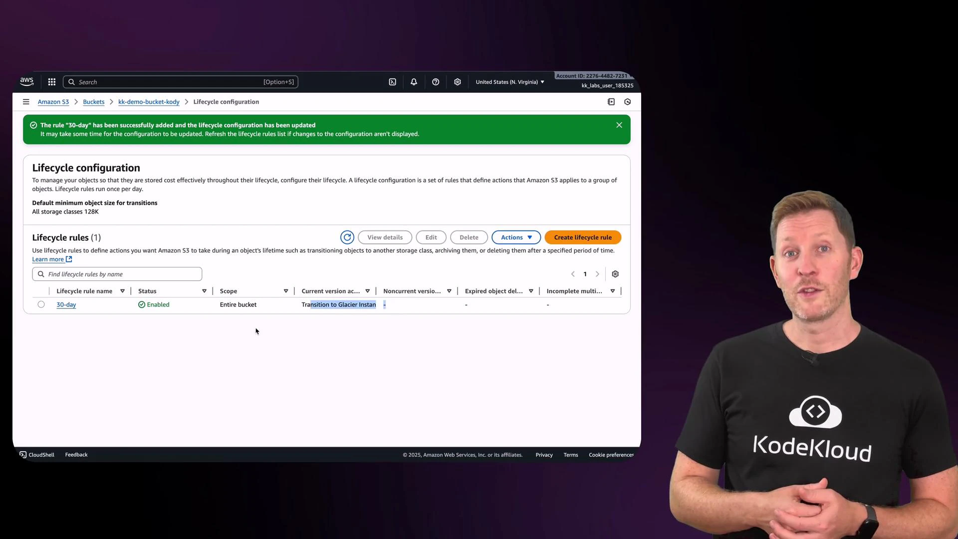 A presenter wearing a black "KodeKloud" t-shirt stands to the right of a large screenshot of the Amazon S3 console showing a "Lifecycle configuration" page and a green success banner. The screen lists a "30-day" lifecycle rule and options to view, edit, delete, or create rules.