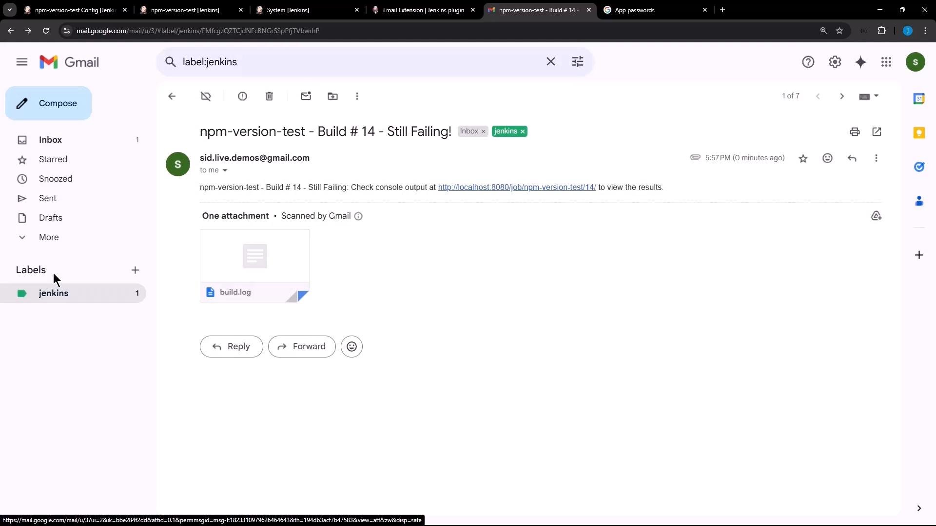 An open Gmail message with the subject "npm-version-test - Build #14 - Still Failing!" showing a build.log attachment. The email body includes a link to a Jenkins job (localhost).