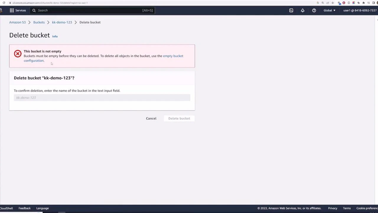 A screenshot of the Amazon S3 console showing a "Delete bucket" dialog with a red warning that the bucket ("kk-demo-123") is not empty and must be emptied before deletion. The dialog asks the user to type the bucket name to confirm deletion.