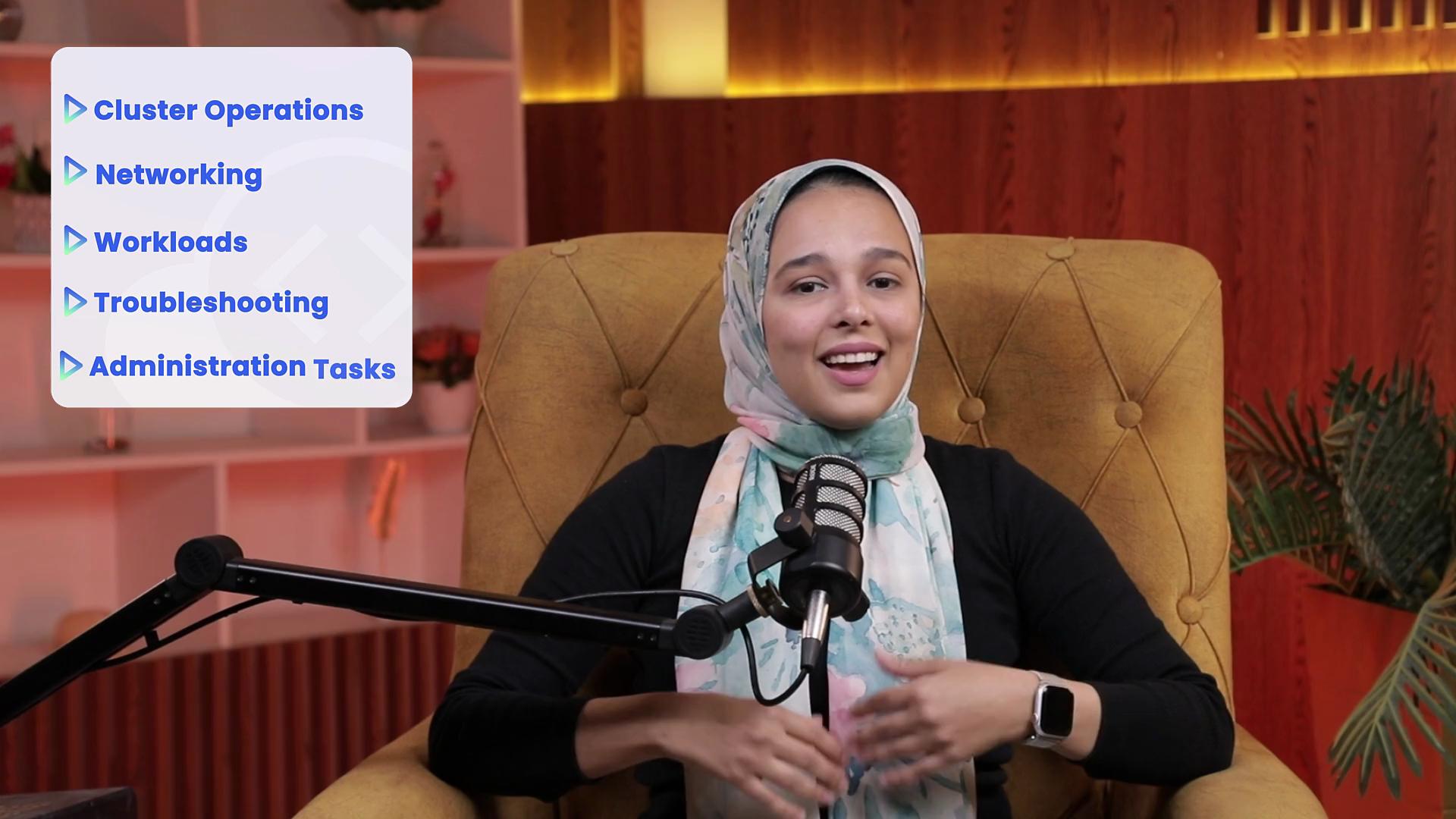 A person is sitting in a chair, speaking into a microphone, with a list of topics on the left that includes "Cluster Operations," "Networking," "Workloads," "Troubleshooting," and "Administration Tasks."