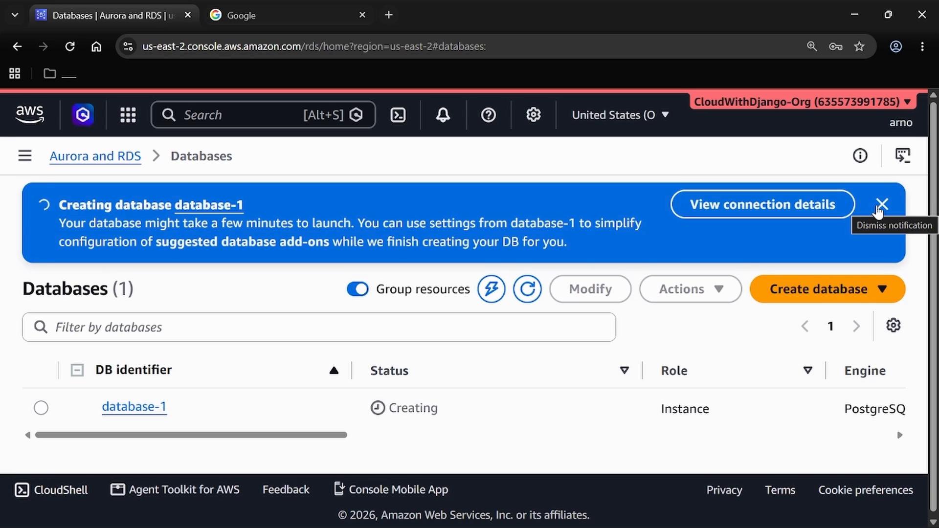 A screenshot of the AWS RDS/Aurora Databases console showing a blue notification that "database-1" is being created, with a "View connection details" button. The page also shows a databases list entry for "database-1" and controls like Create database, Modify, and Actions.