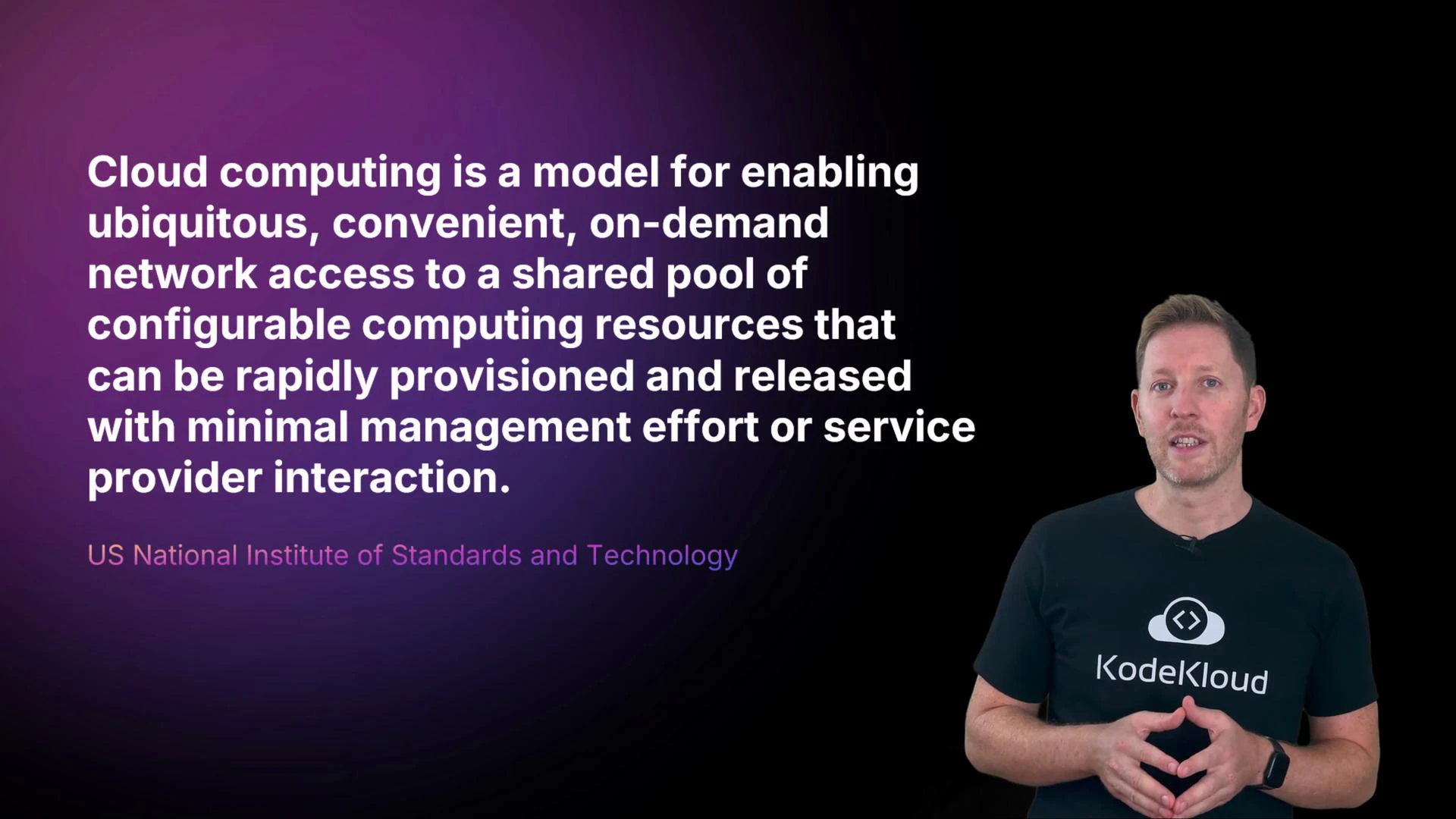 A slide displaying the US NIST definition of cloud computing in large white text on a purple-to-black background. A presenter stands to the right wearing a black "KodeKloud" t-shirt.