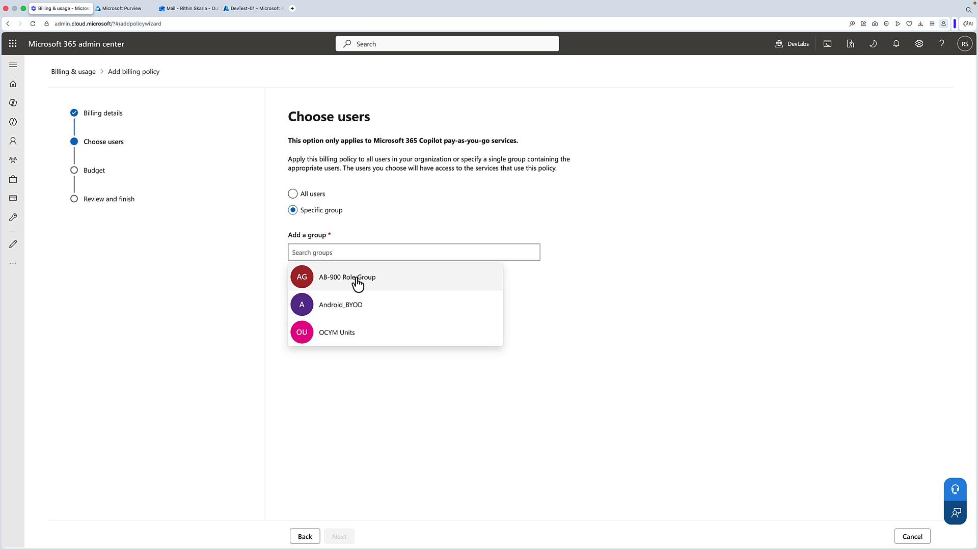 A screenshot of the Microsoft 365 admin center on the "Choose users" step for adding a billing policy, with "Specific group" selected and a dropdown showing groups like "AB-900 RoleGroup," "Android_BYOD," and "OCYM Units." The left pane shows the policy setup progress (Billing details checked, Choose users active, Budget and Review pending).