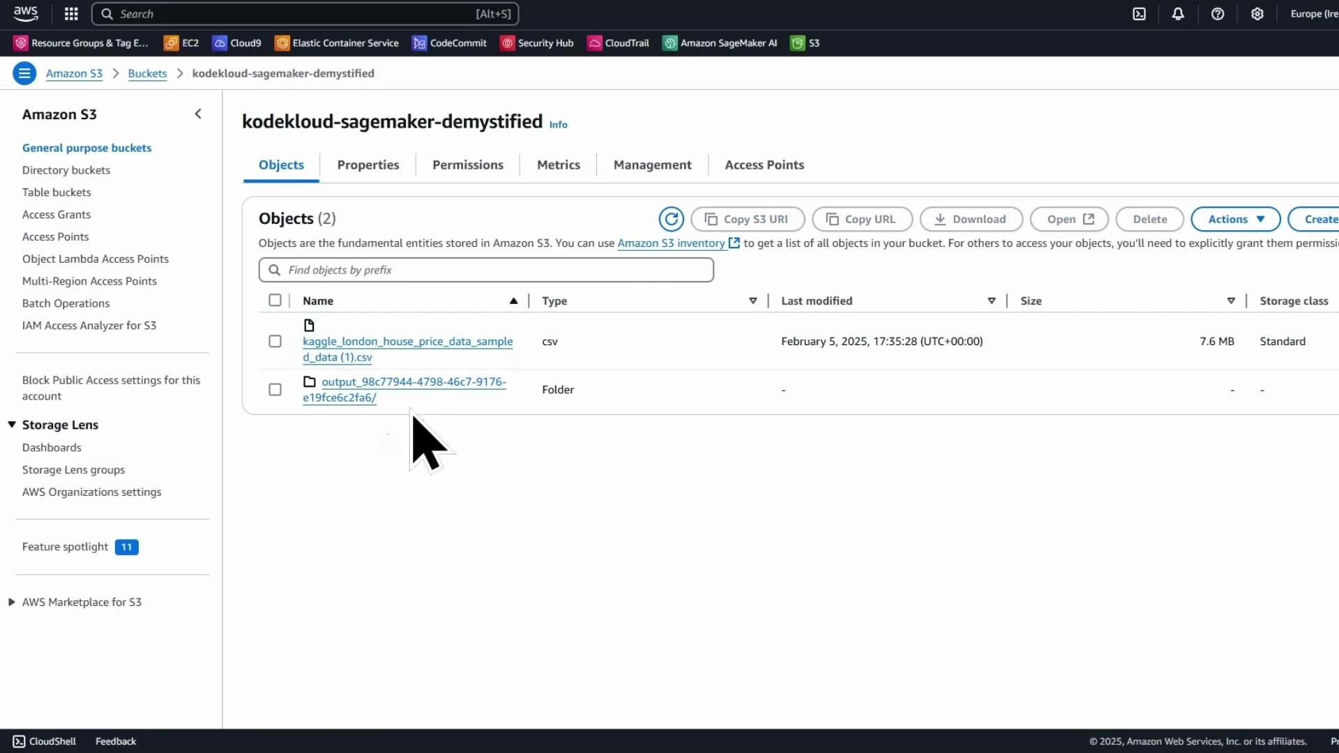 A screenshot of the Amazon S3 web console opened to the bucket "kodekloud-sagemaker-demystified," showing two objects: a CSV file named something like "kaggle_london_house_price_data_sample..." and an output folder. The UI shows tabs for Objects/Properties/Permissions and action buttons (Copy S3 URI, Download, Delete, etc.).