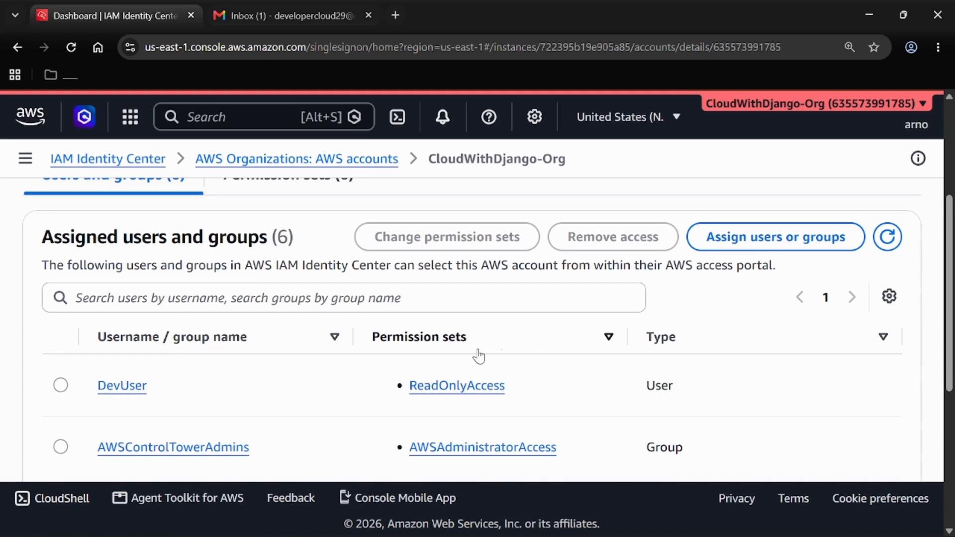 A screenshot of the AWS IAM Identity Center (AWS Organizations) console showing the "Assigned users and groups" page with listed accounts like DevUser and AWSControlTowerAdmins and their permission sets (e.g., ReadOnlyAccess, AWSAdministratorAccess).