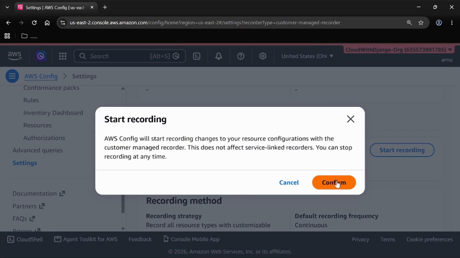 A screenshot of the AWS Config settings page with a "Start recording" confirmation dialog explaining that AWS Config will begin recording resource configuration changes. The dialog shows "Cancel" and an orange "Confirm" button.