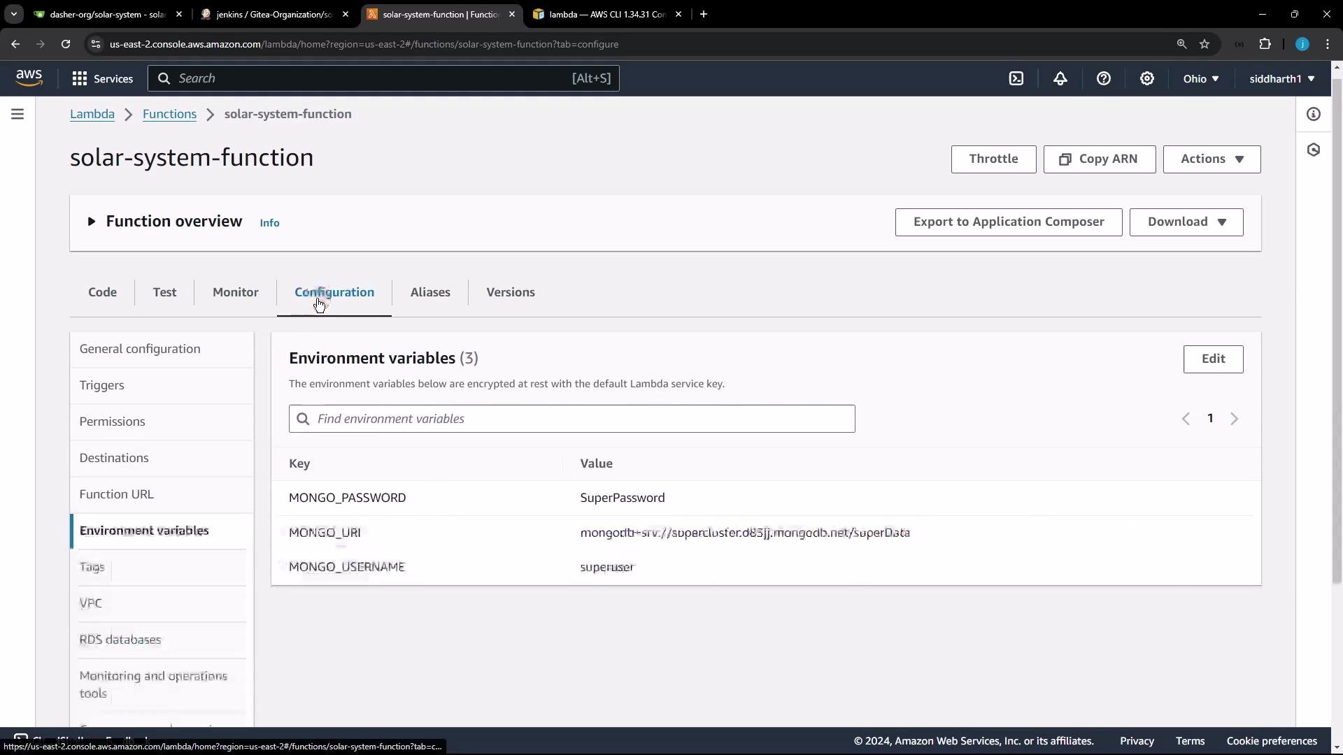A screenshot of the AWS Lambda console for a function named "solar-system-function," open to the Configuration → Environment variables tab showing keys like MONGO_PASSWORD, MONGO_URI, and MONGO_USERNAME with their values. The page also shows navigation tabs, action buttons (Throttle, Copy ARN, Actions), and the left-side configuration menu.