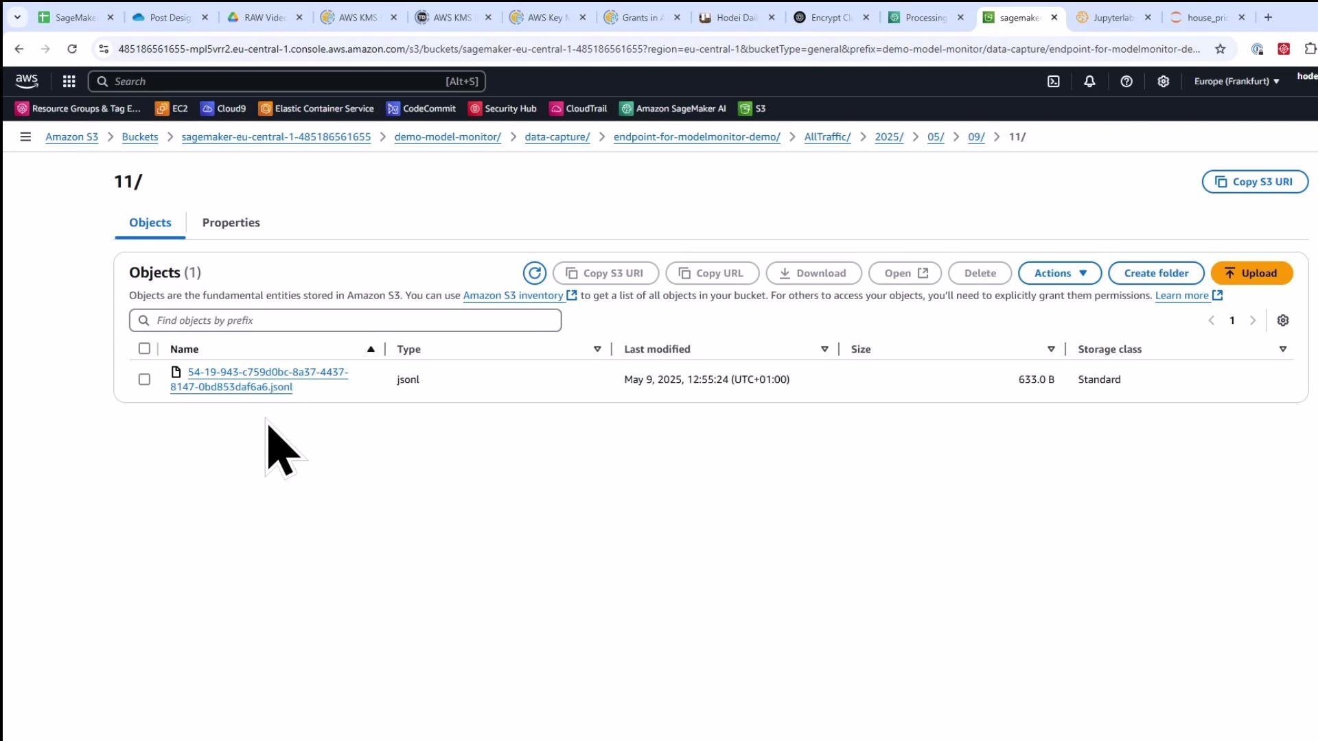 Screenshot of the AWS S3 console showing a Sagemaker bucket folder with one .jsonl object listed and a large mouse cursor pointer. The file was last modified May 9, 2025 and is 633.0 B in size.