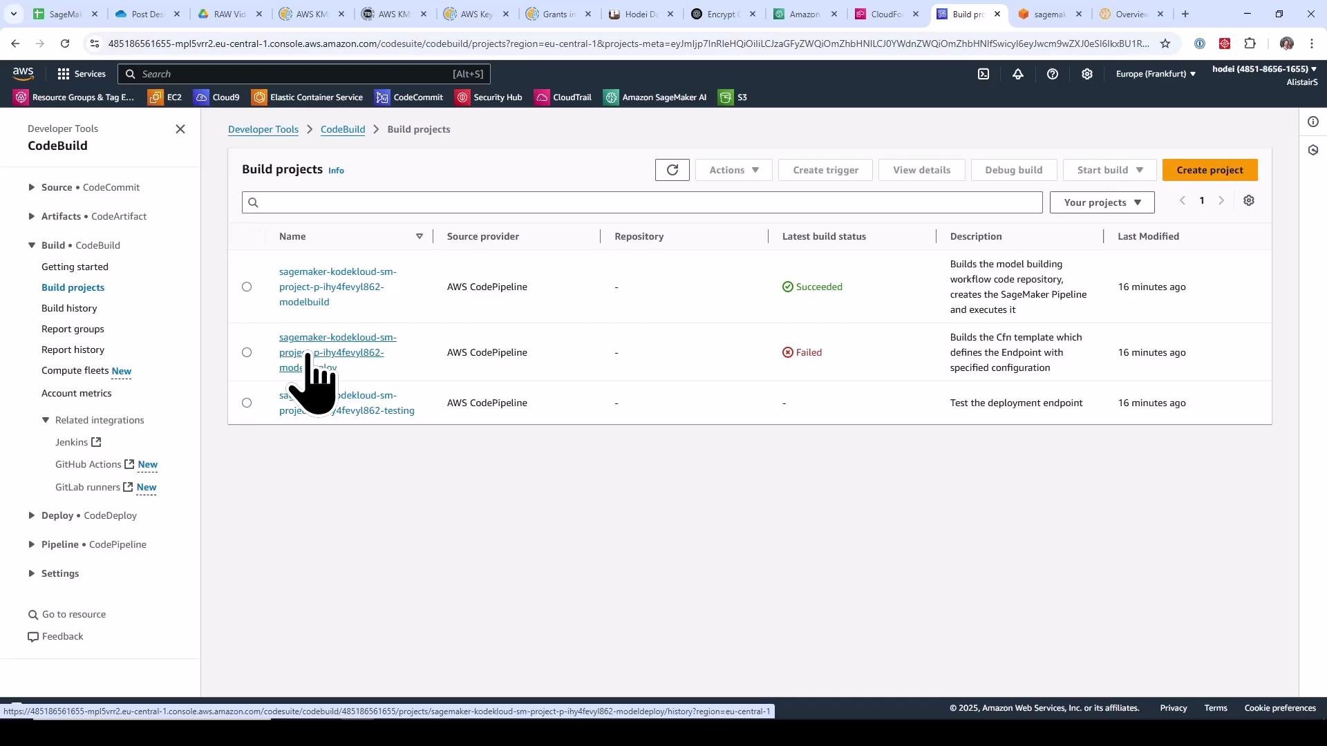 A screenshot of the AWS CodeBuild "Build projects" page showing a list of build projects, their source provider (AWS CodePipeline), and latest build statuses (one Succeeded, one Failed). A pointer/hand cursor is hovering over one of the project names.