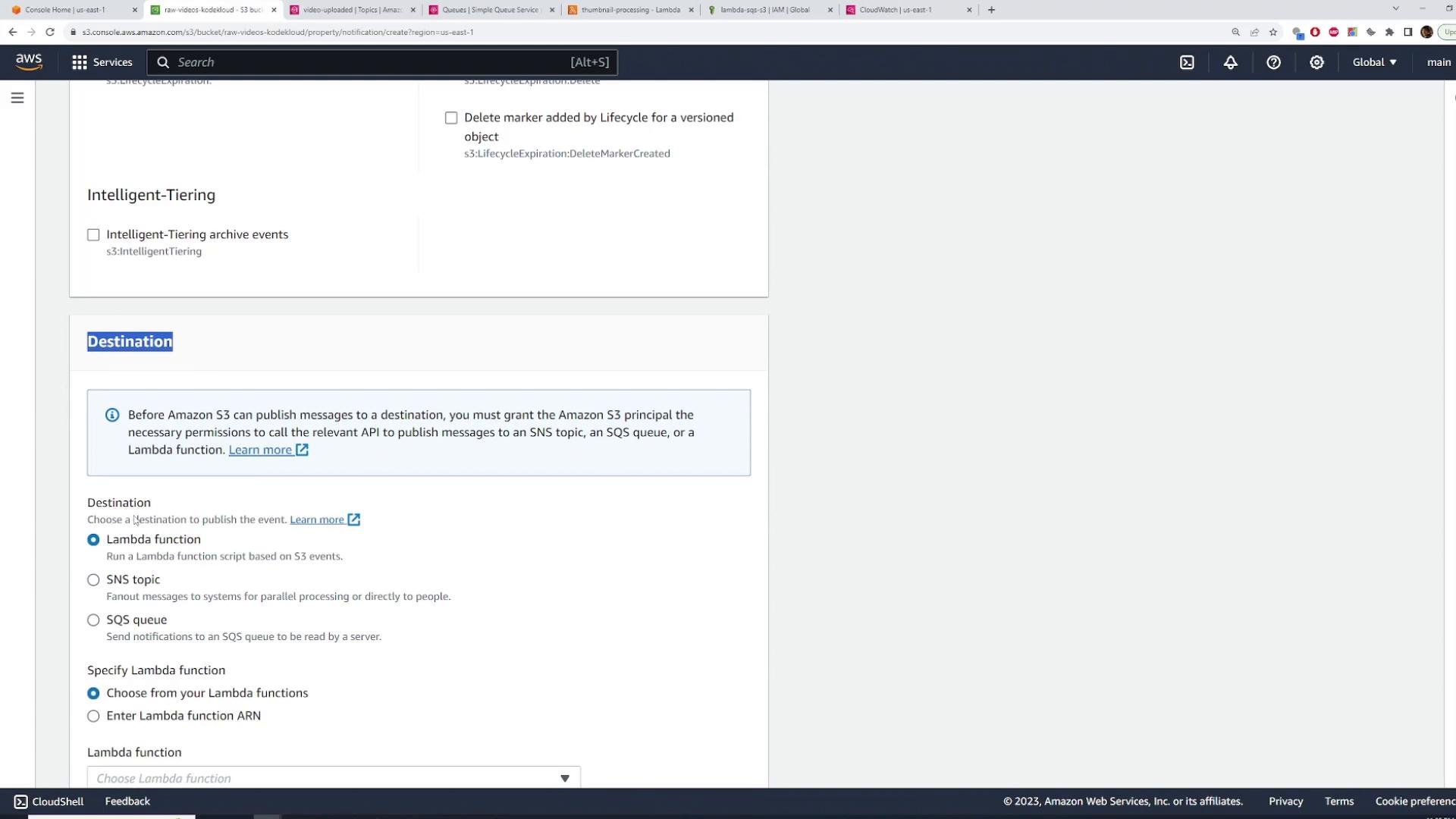 A screenshot of the AWS S3 console showing the "Destination" section for configuring event notifications, with radio options for Lambda function, SNS topic, and SQS queue. The page also shows an Intelligent-Tiering option and an informational box about granting S3 permissions to publish to destinations.